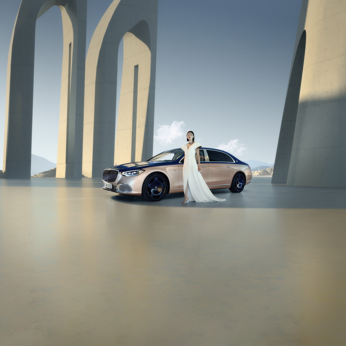 Upplev Mercedes-Maybach Kvinna i vit klänning framför tvåfärgad Mercedes-Maybach-bil