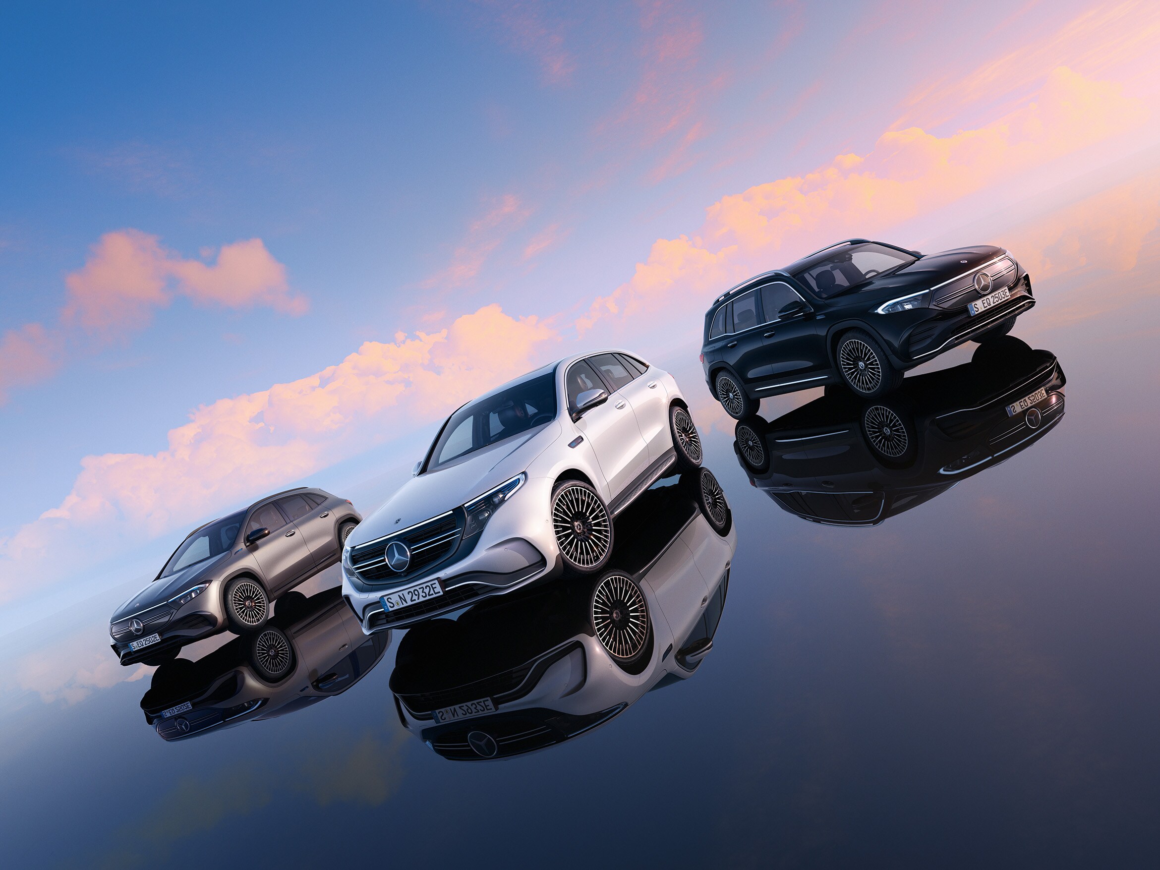 Tre 7-sitsiga suvar från Mercedes-Benz parkerade i en solnedgång.
