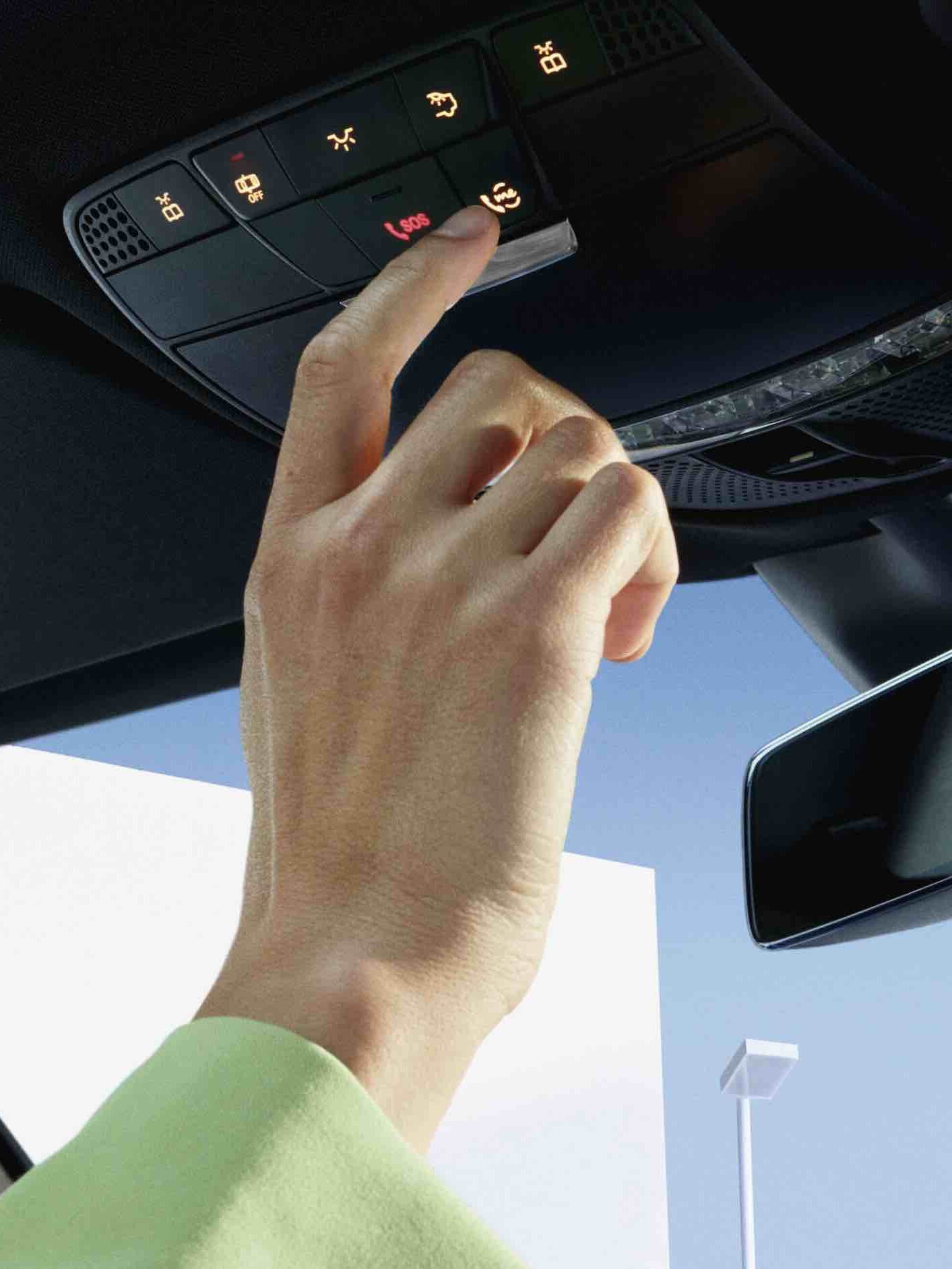 Vägassistans-knappen i takkontrollpanelen i en Mercedes-Benz trycks in.