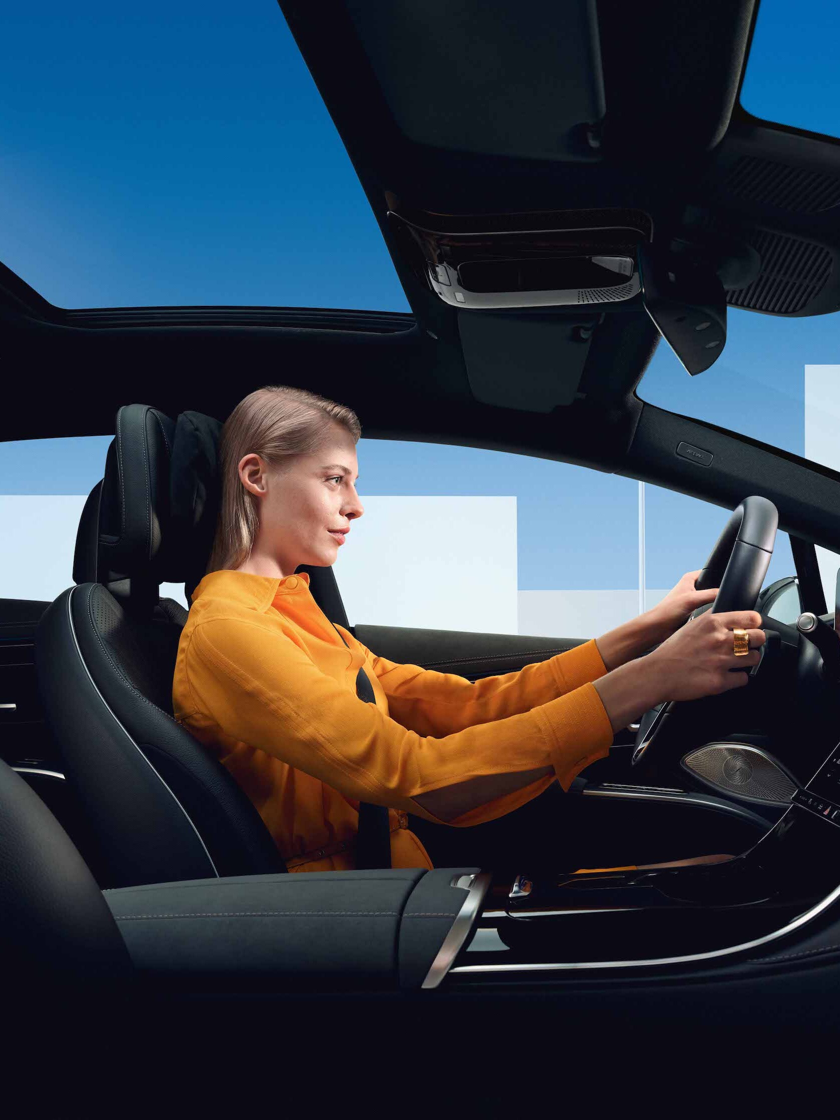 En kvinna sitter bakom ratten i sin Mercedes-Benz.