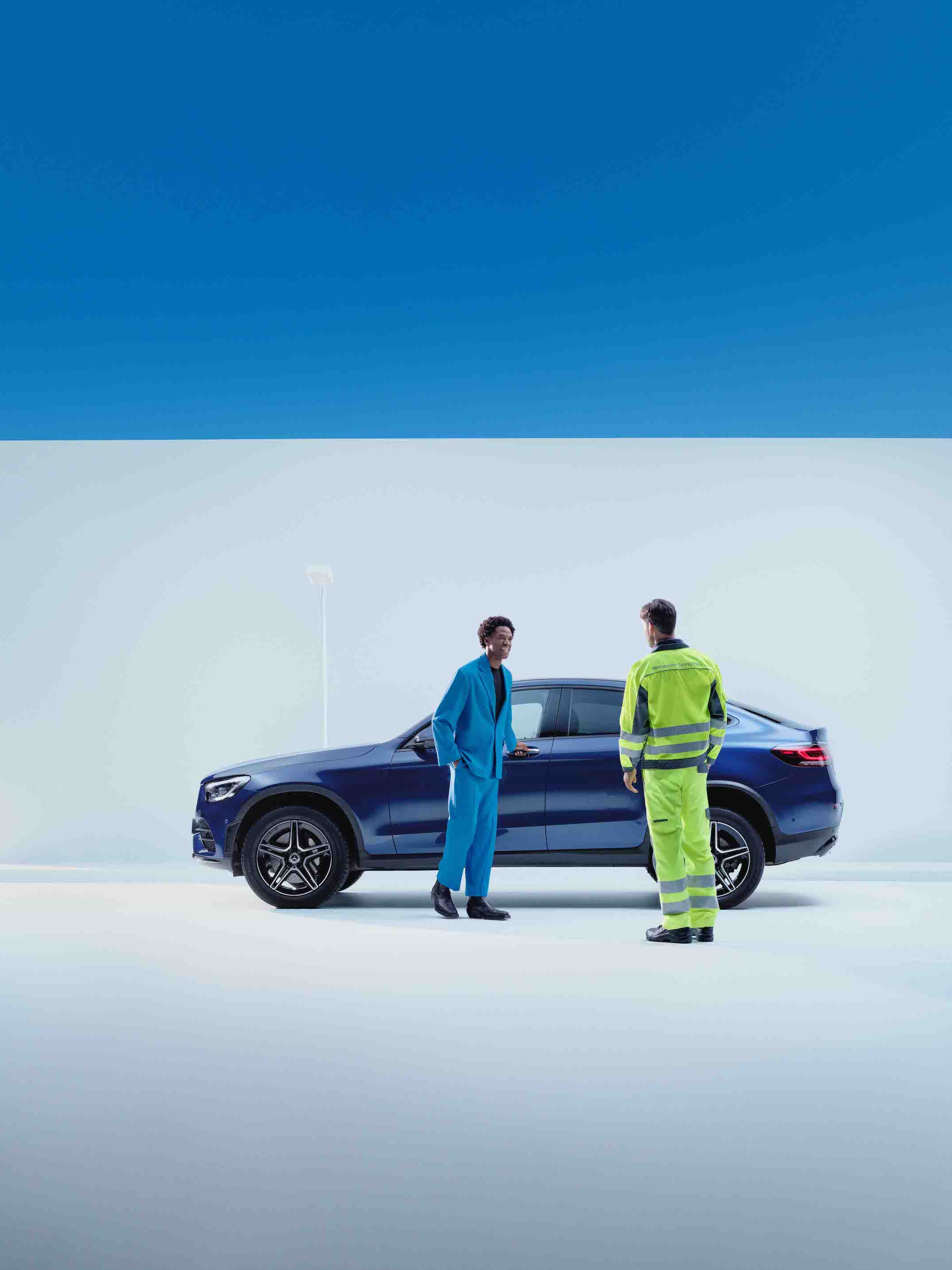 En man står framför en Mercedes-Benz tillsammans med en servicemedarbetare.