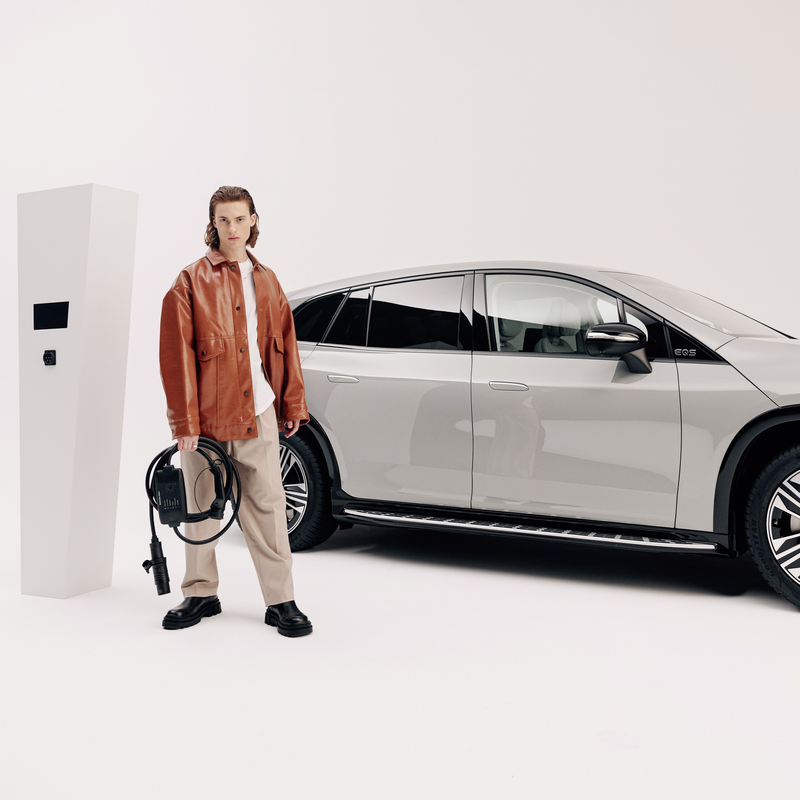 En man står framför sin Mercedes-Benz EQS SUV