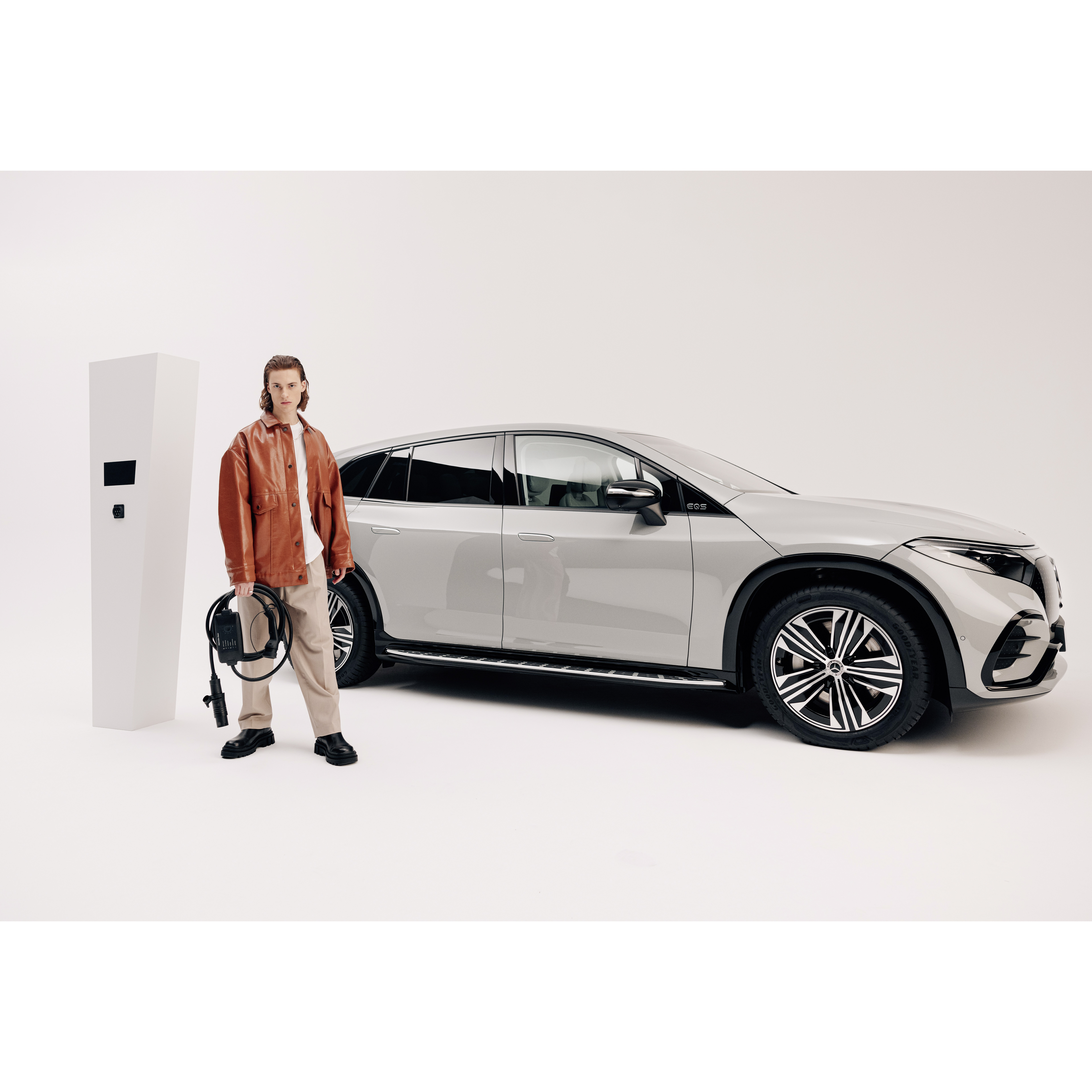 Flexibelt laddningssystem Pro | Laddning | Mercedes-Benz En man står framför sin Mercedes-Benz EQS SUV