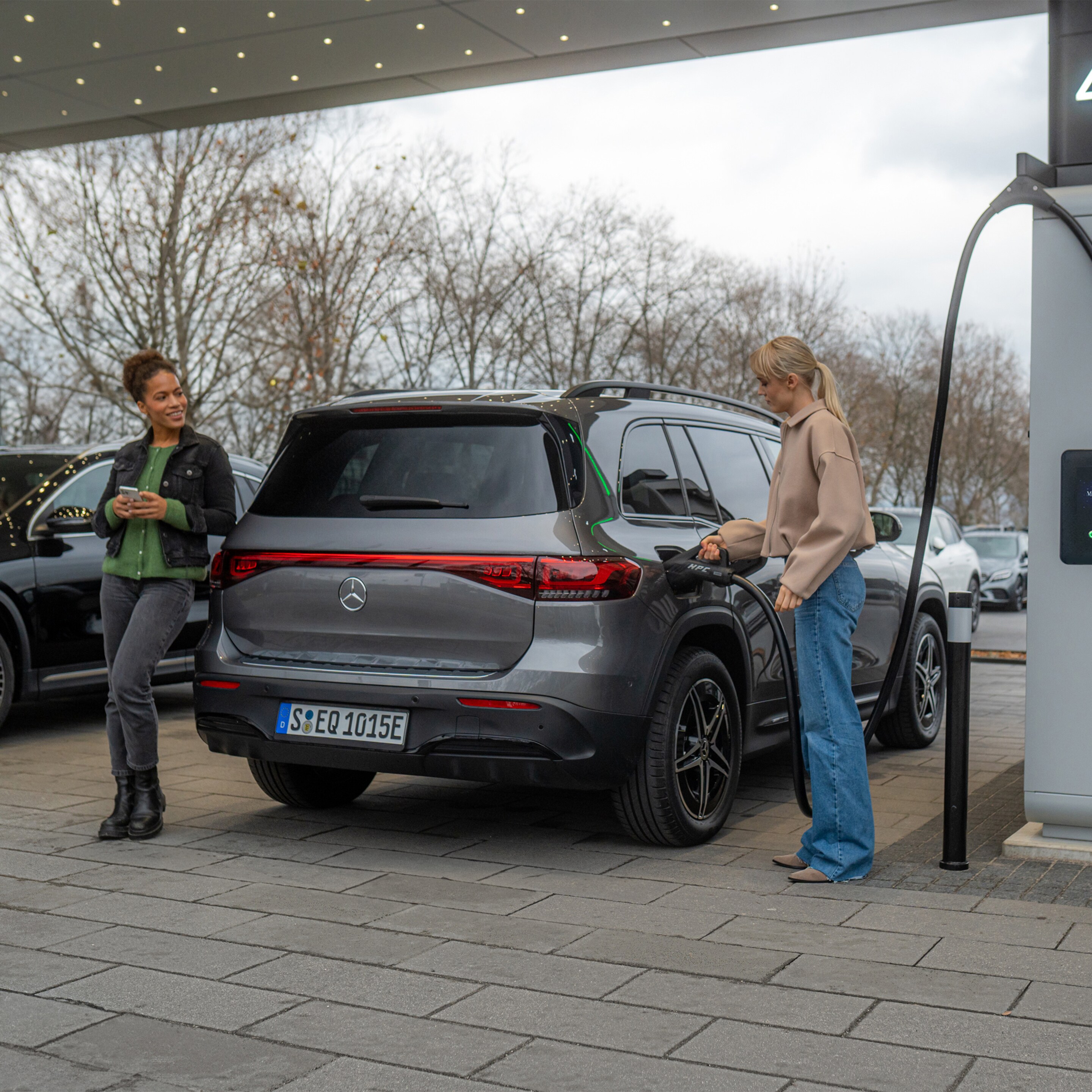 Två Mercedes-Benz elbilar vid en laddningsstation.
