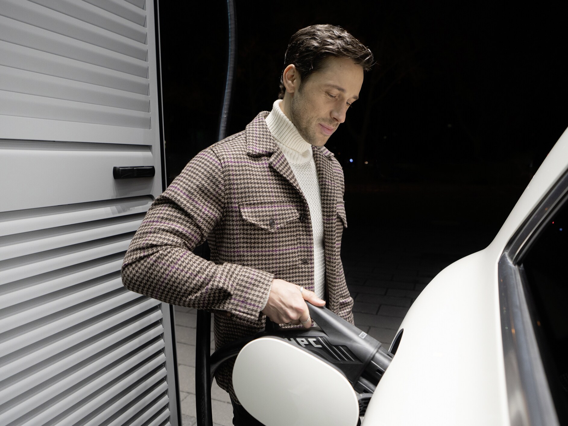 En man laddar sin Mercedes-Benz elbil med MB.CHARGE Public