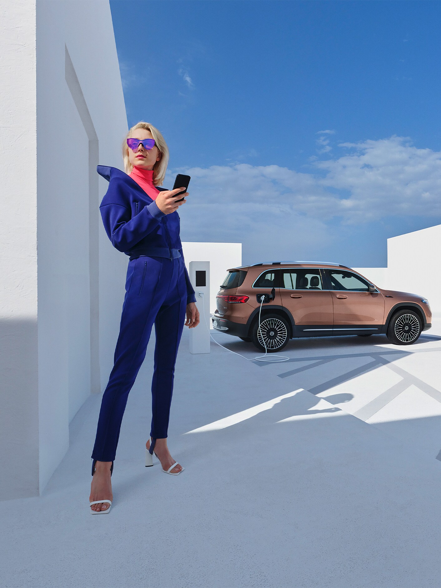 En kvinna laddar sin Mercedes-Benz EQB vid en laddstolpe från IONITY.