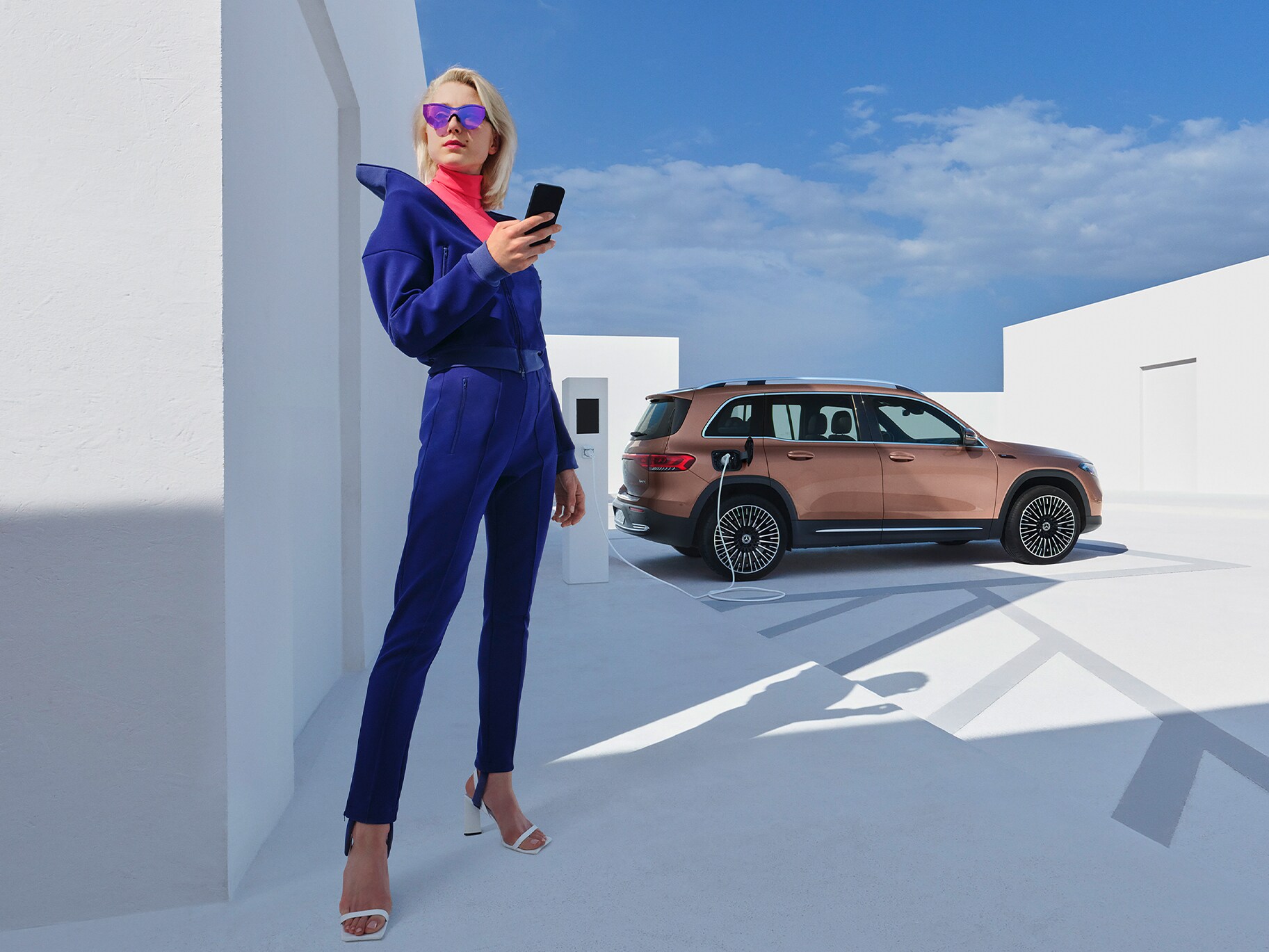 En kvinna laddar sin Mercedes-Benz EQB vid en laddstolpe från IONITY.