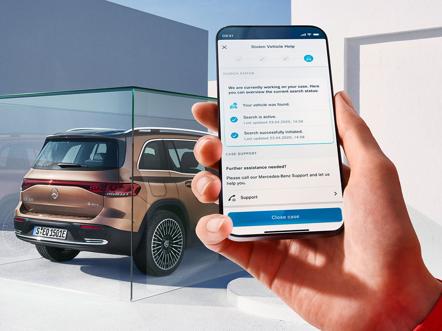 Person använder GUARD 360 på sin smartphone bredvid en Mercedes-Benz EQB.