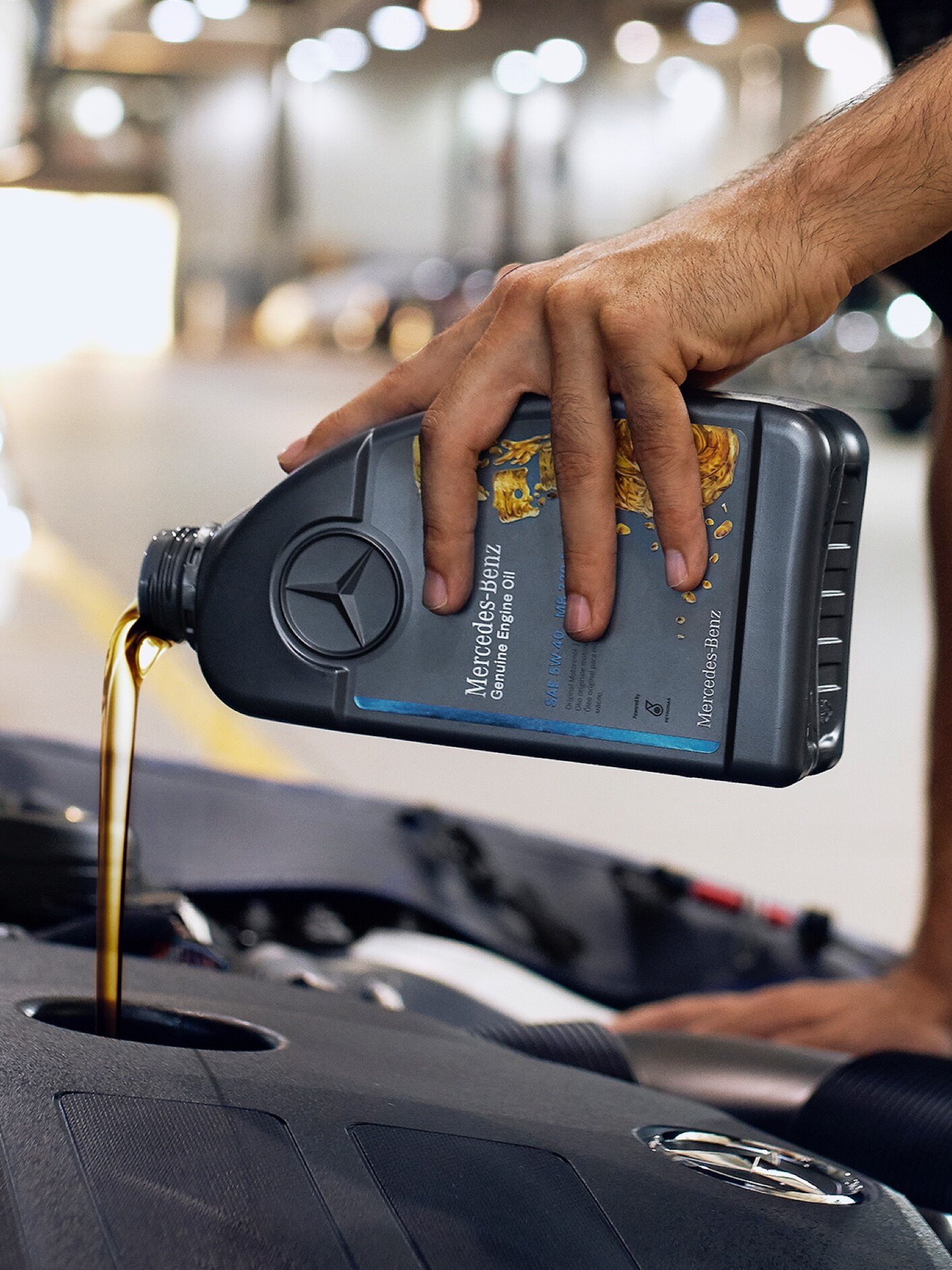 En Mercedes-Benz tekniker fyller på originalmotorolja.