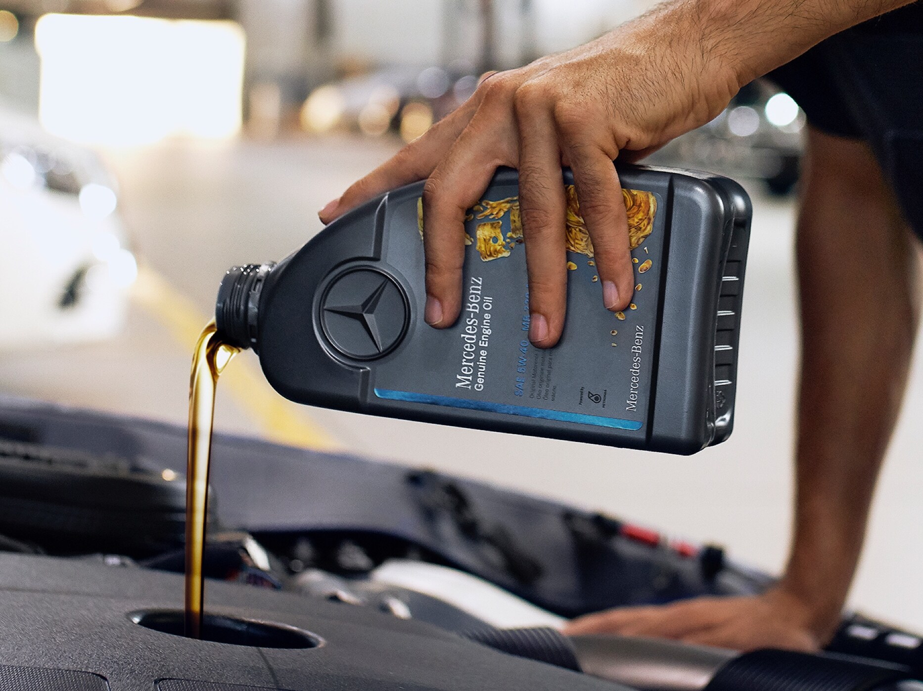 En Mercedes-Benz tekniker fyller på originalmotorolja.