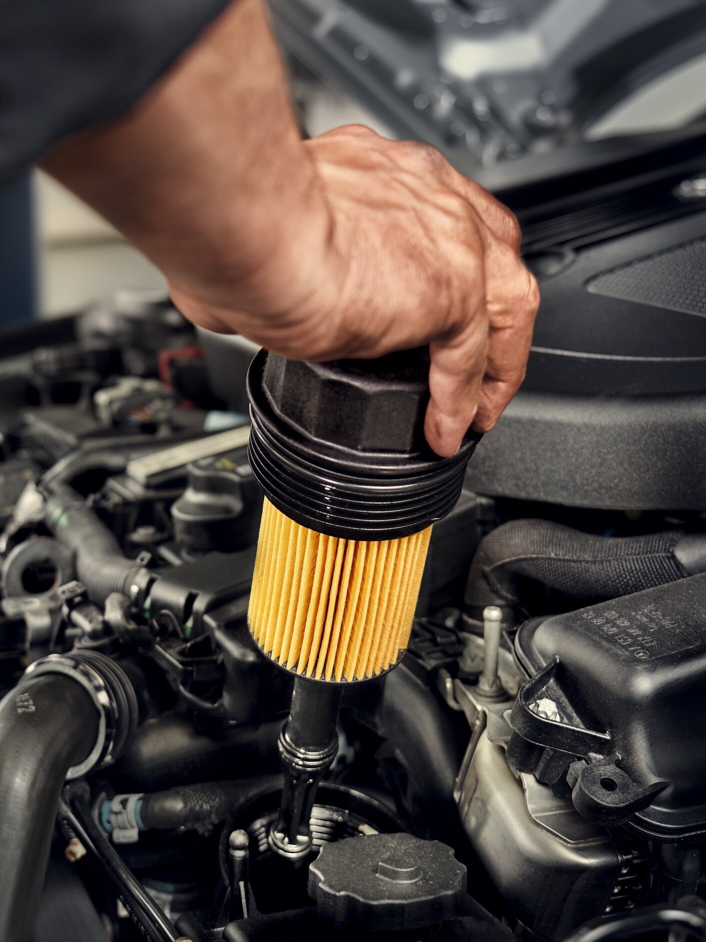 En Mercedes-Benz tekniker byter oljefiltret i bilen.