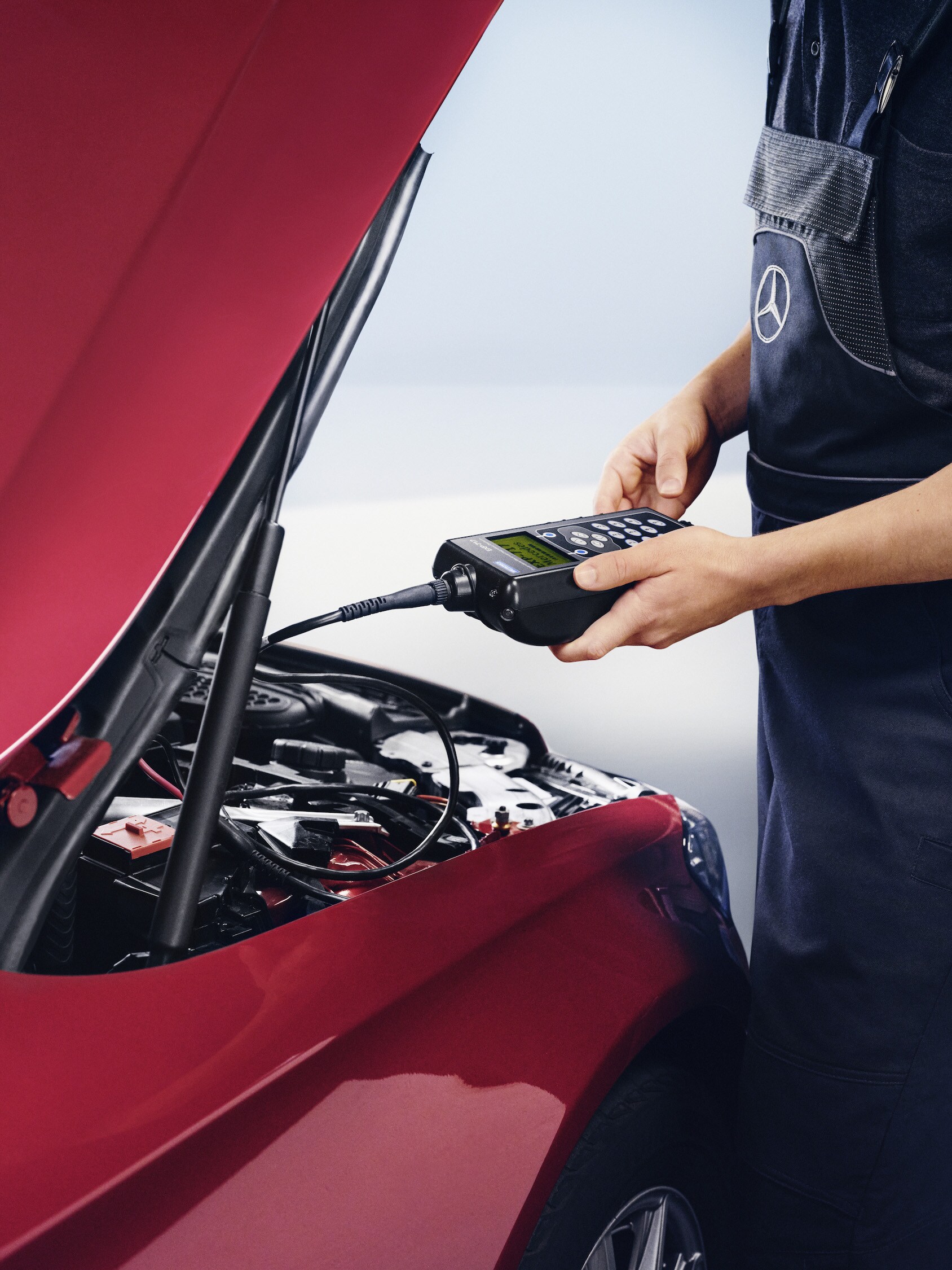 En Mercedes-Benz tekniker kontrollerar bilens batteri.