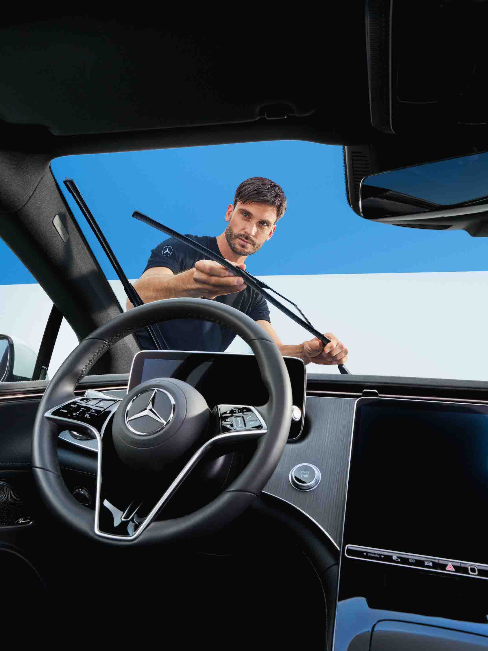 En Mercedes-Benz tekniker byter vindrutetorkarna på bilen.