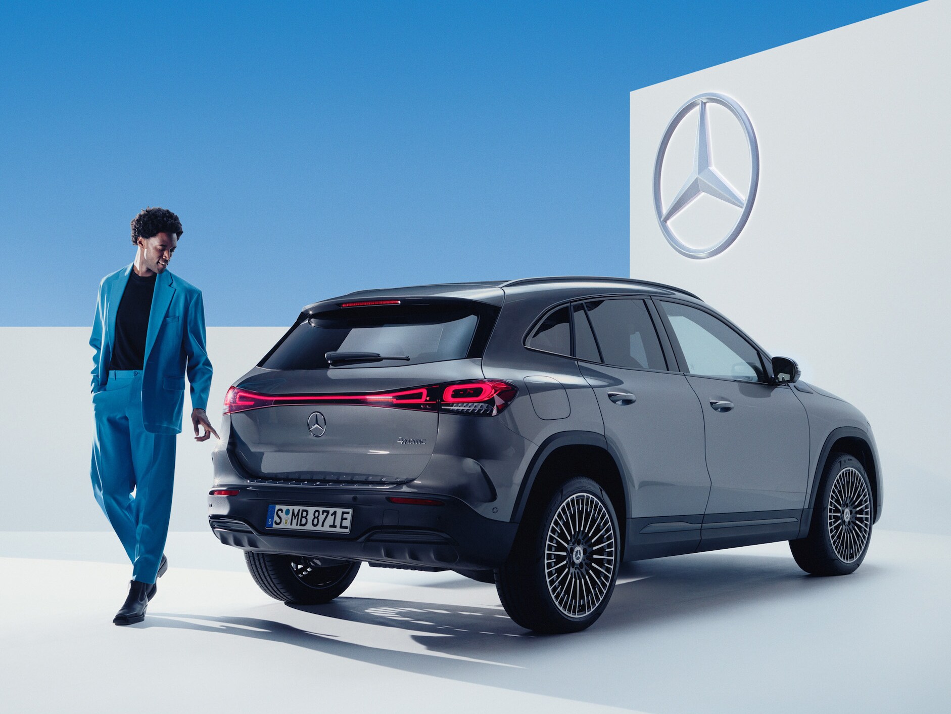 Person står fram en grå Mercedes-Benz EQA