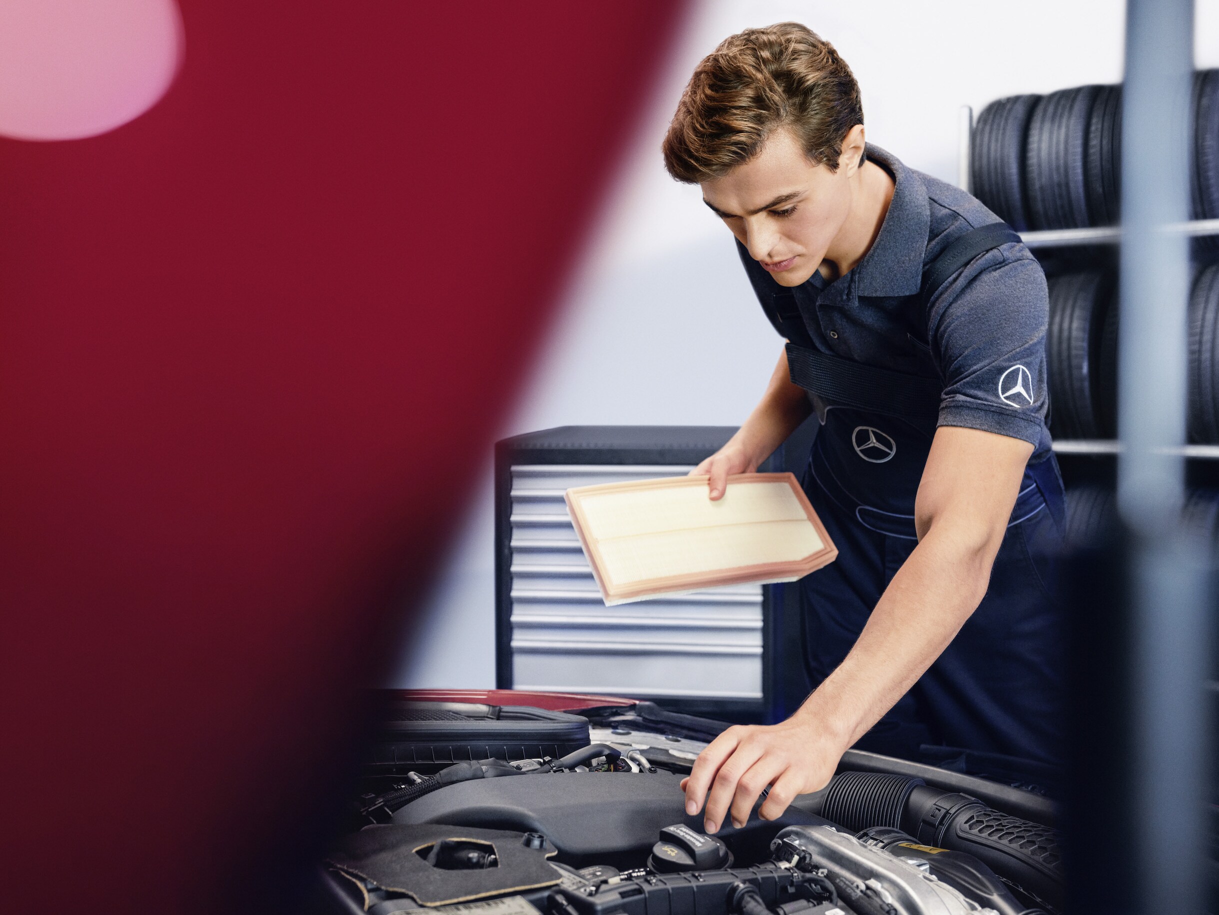 En Mercedes-Benz-tekniker kontrollerar motorrummet i ett fordon.