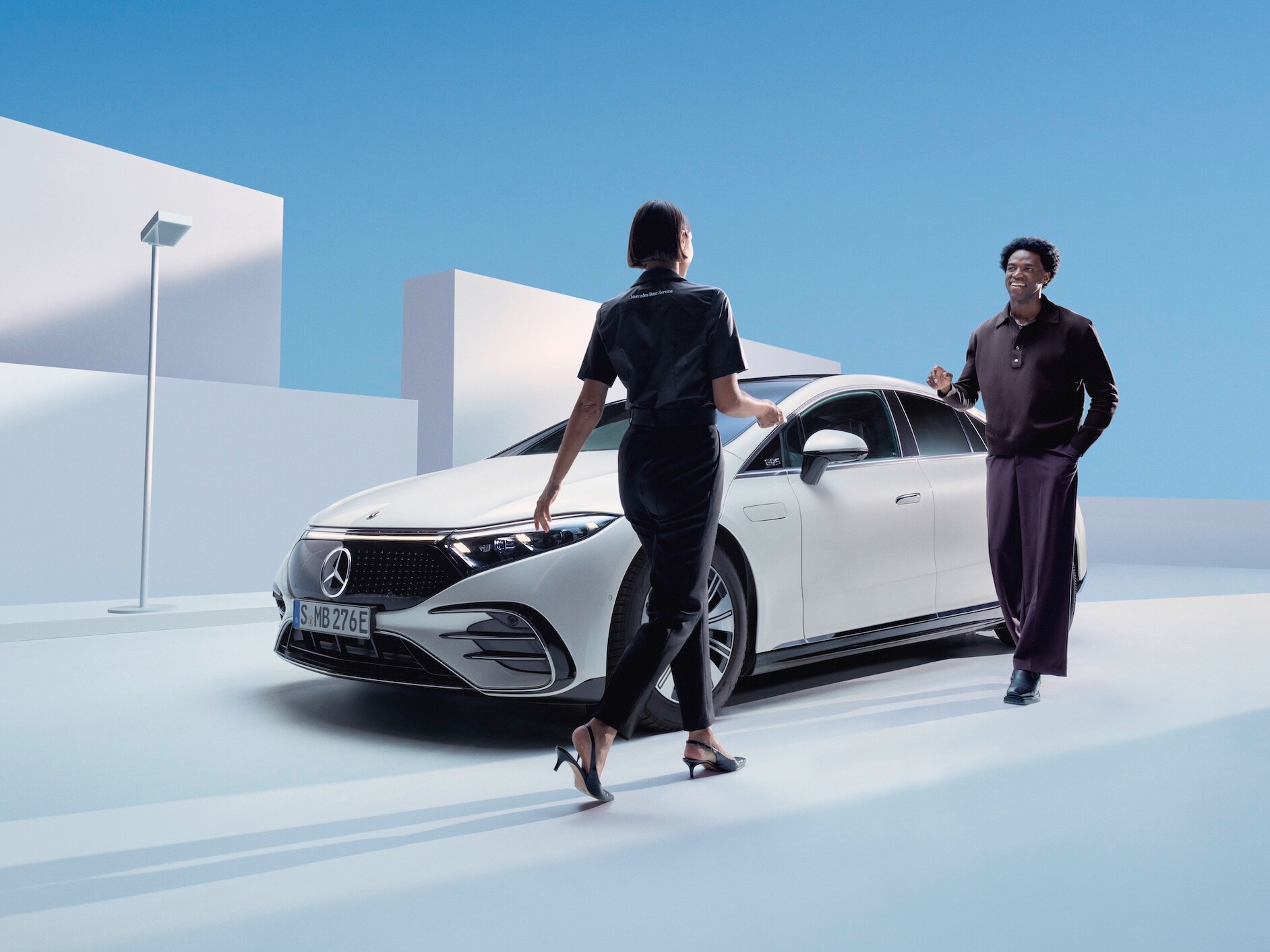 Mercedes-Benz medarbetare rådgiver kund framför en vit EQS sedan