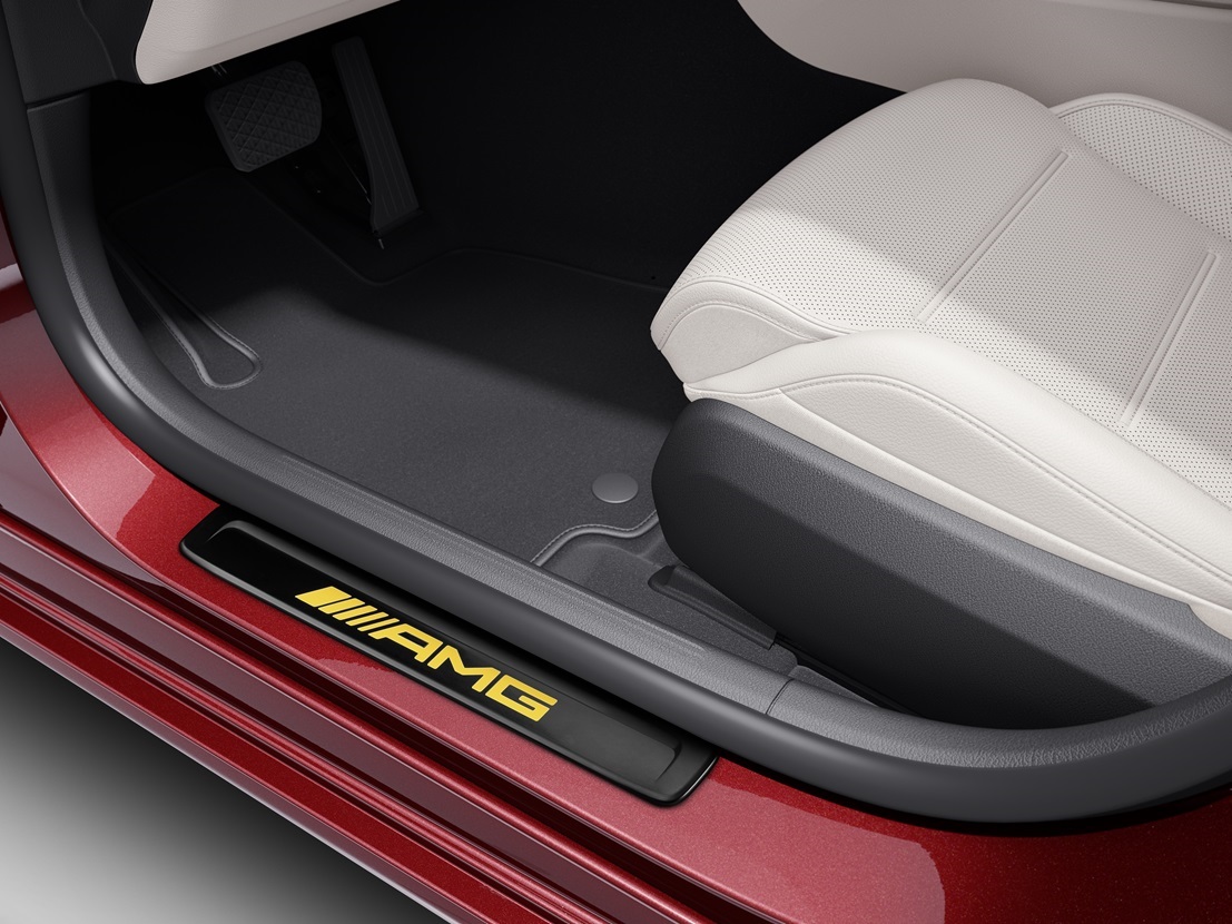 AMG utbytbara skydd | Mercedes-Benz En röd Mercedes-Benz med en utbytbar AMG-instegslist med gul AMG-logga.