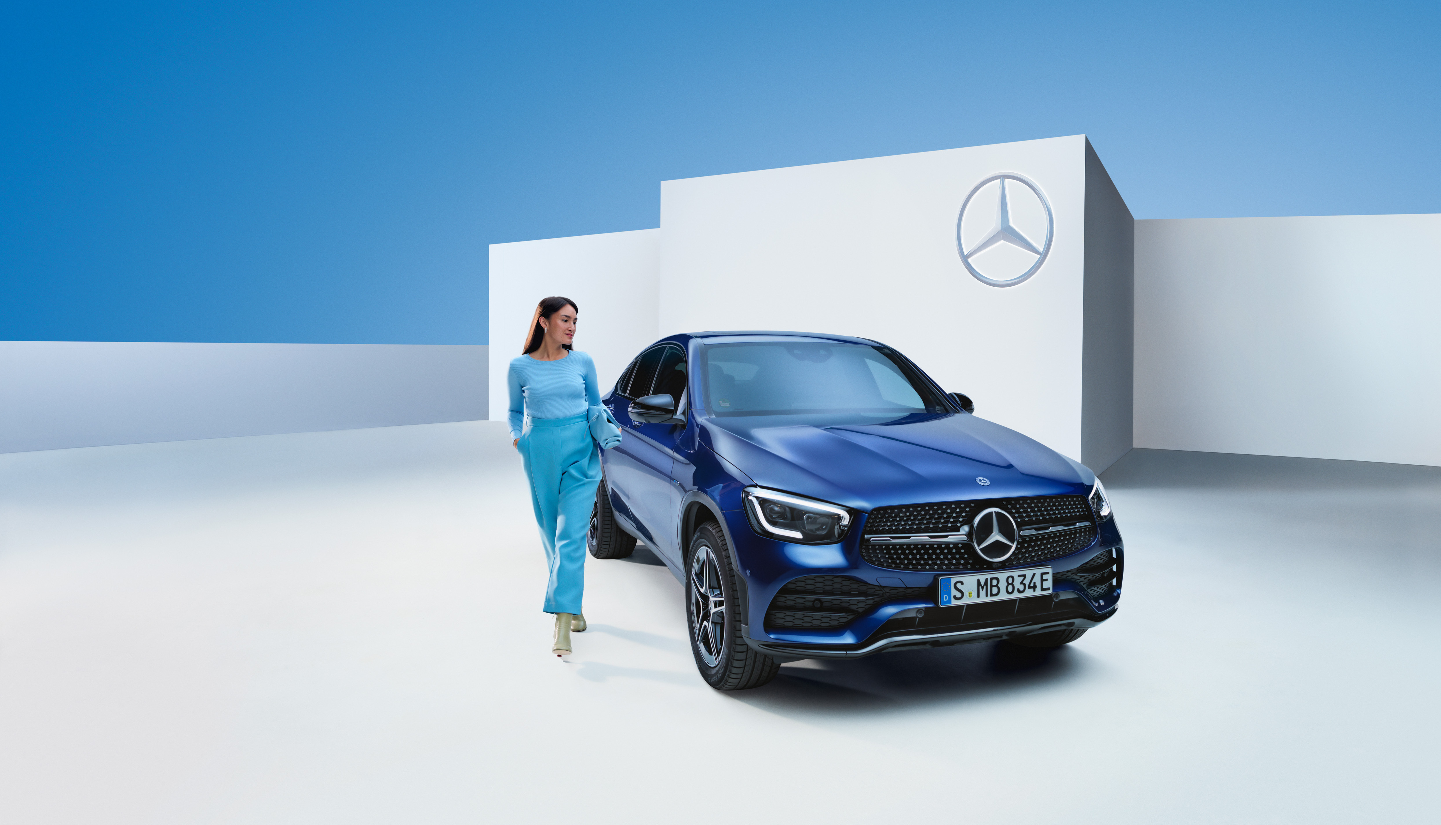 Mercedes-Benz garanti | Mercedes-Benz Kvinna står bredvid sin blåa Mercedes-Benz Coupé