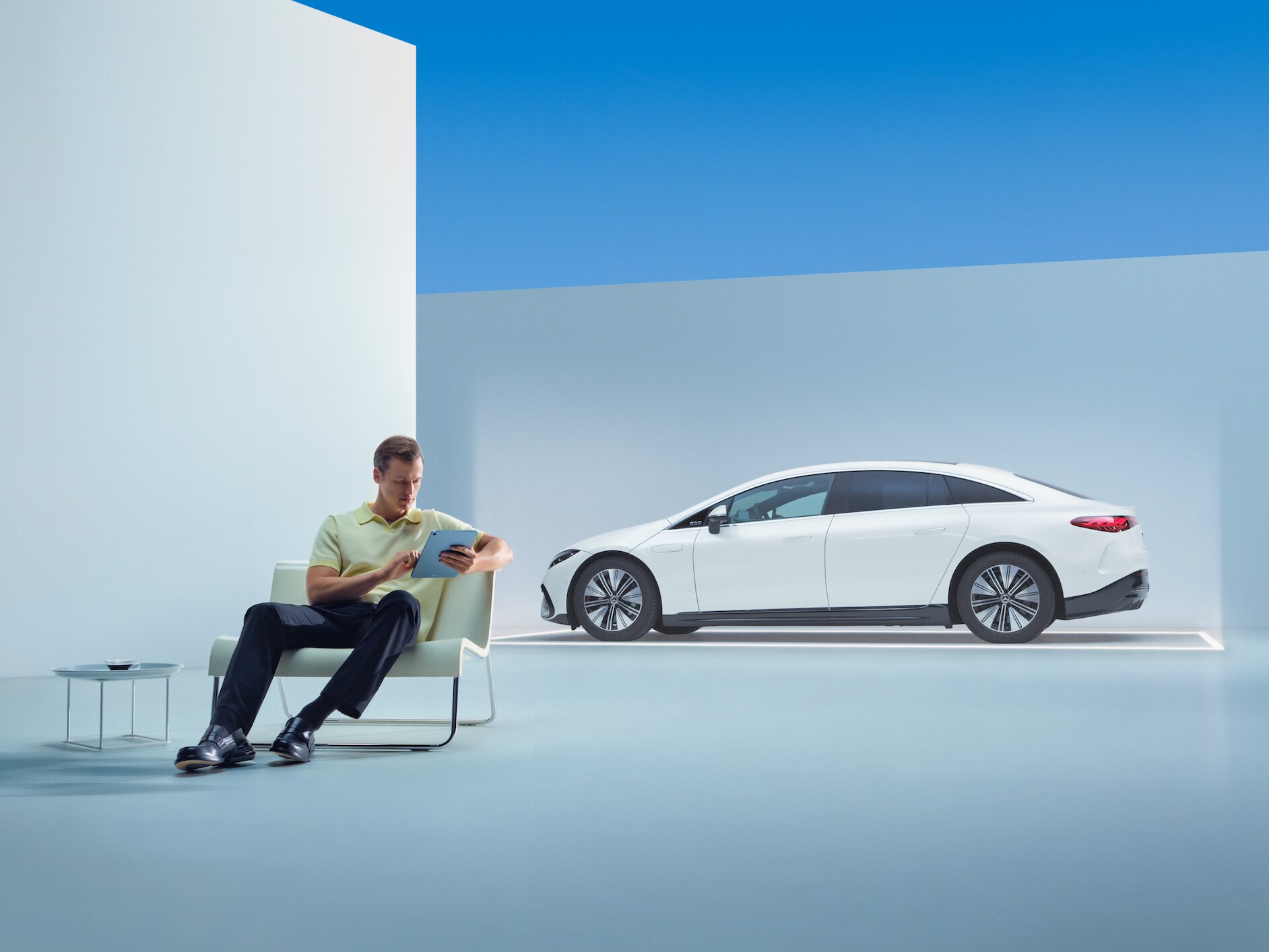 En person sitter framför sin Mercedes med sin surfplatta