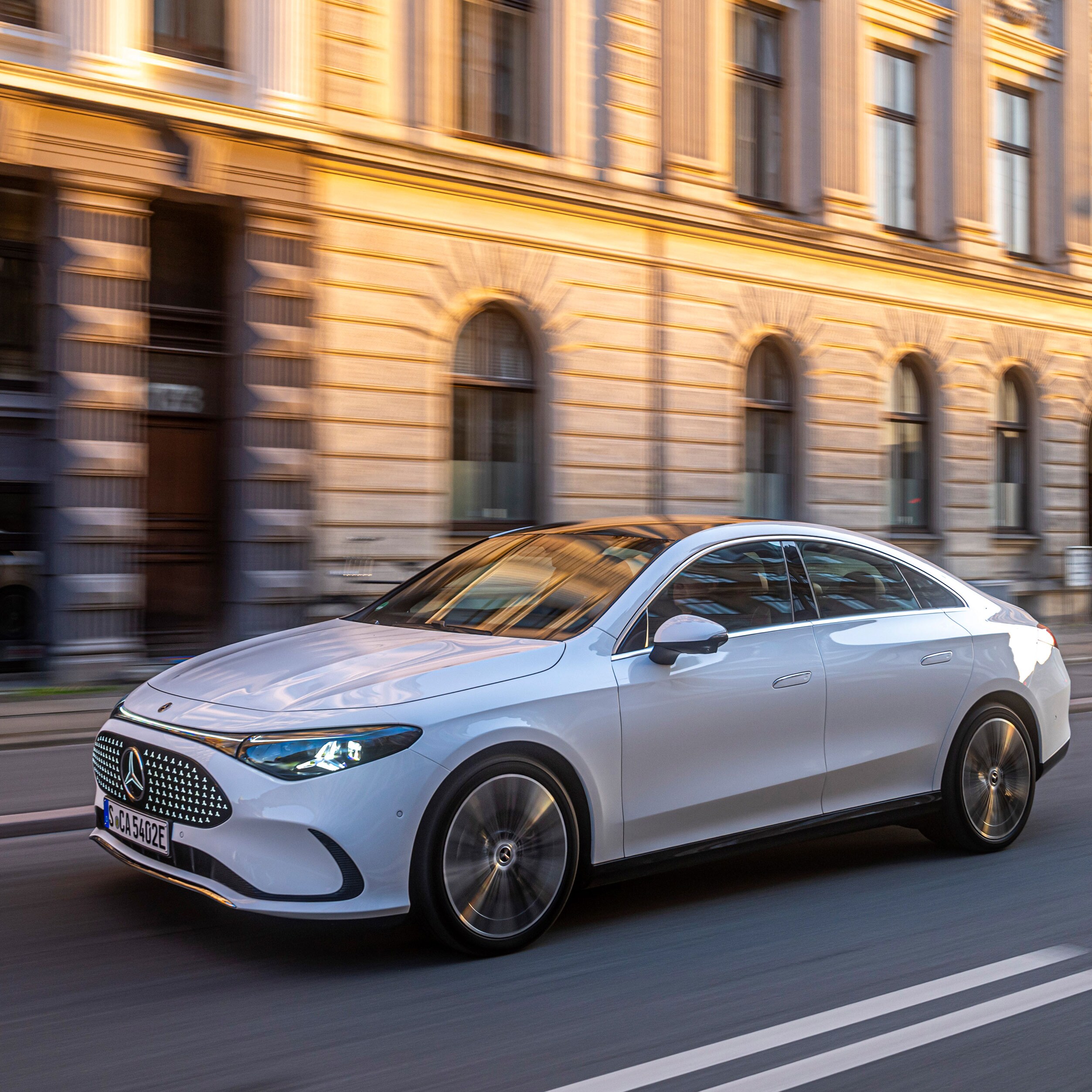 Vit Mercedes-Benz kör genom en storstad.