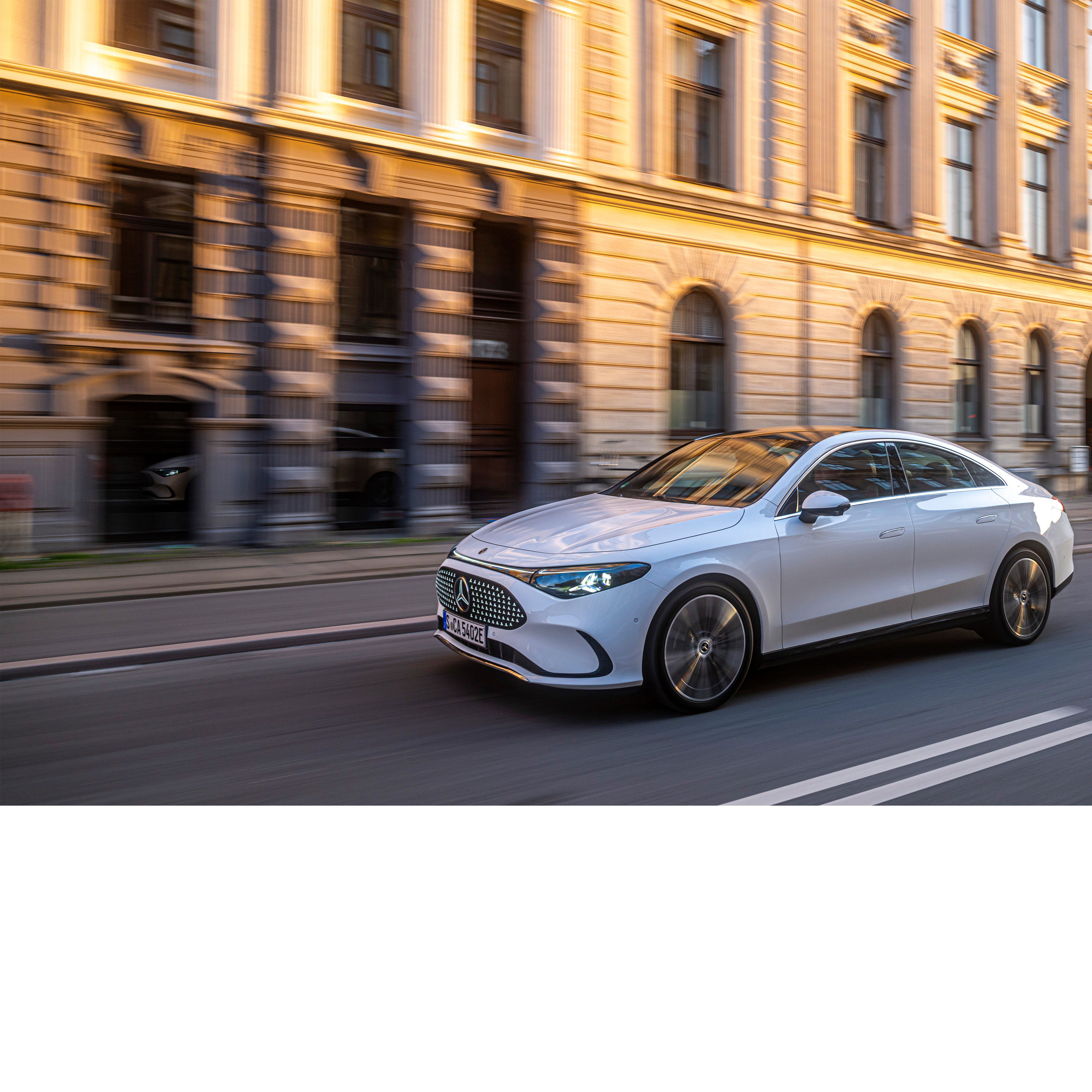 Automatiserad körning & hjälpsystem | Mercedes-Benz Vit Mercedes-Benz kör genom en storstad.