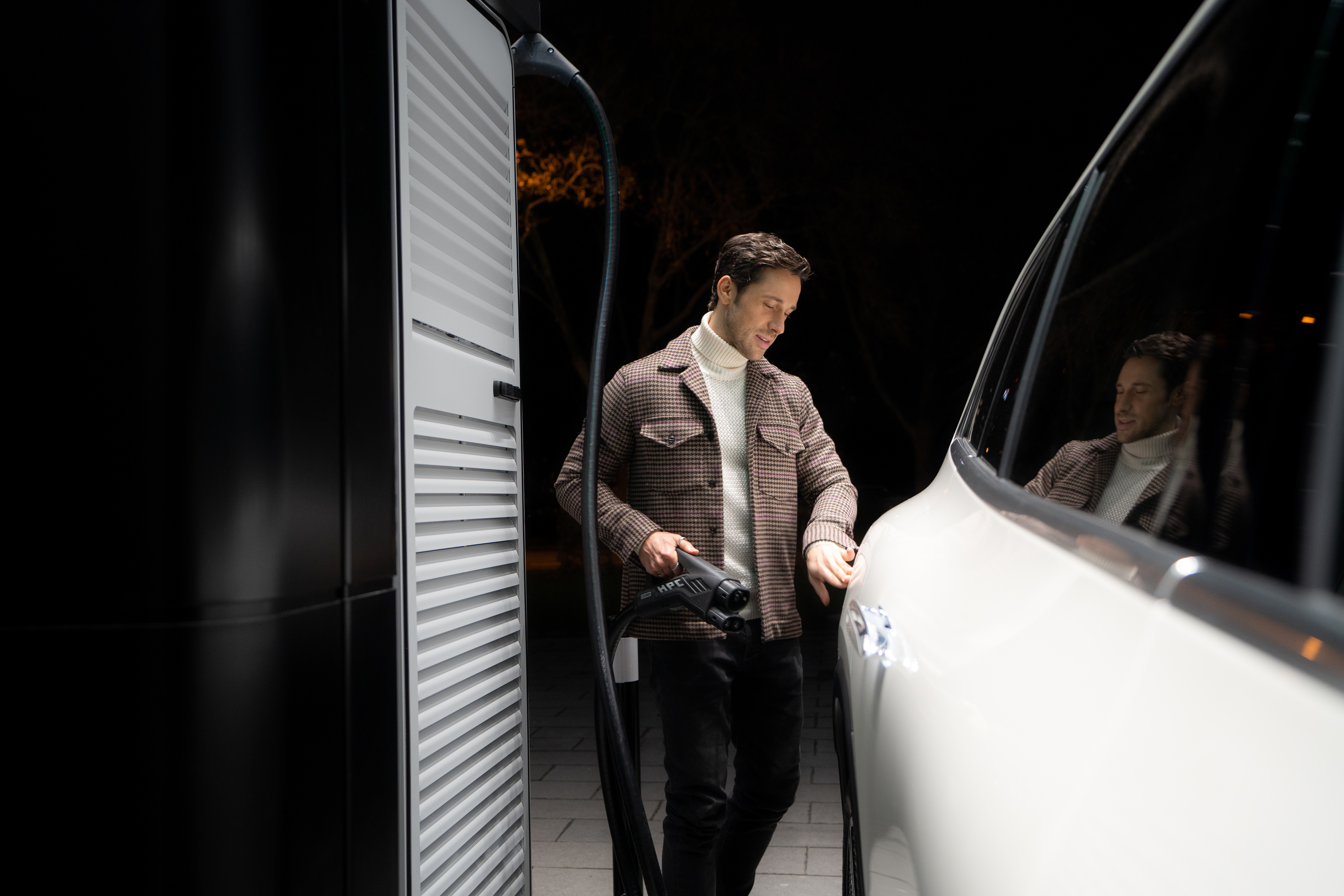 Laddningslösningar | Mercedes-Benz Man laddar sin elektriska Mercedes-Benz med en Mercedes-Benz Wallbox.