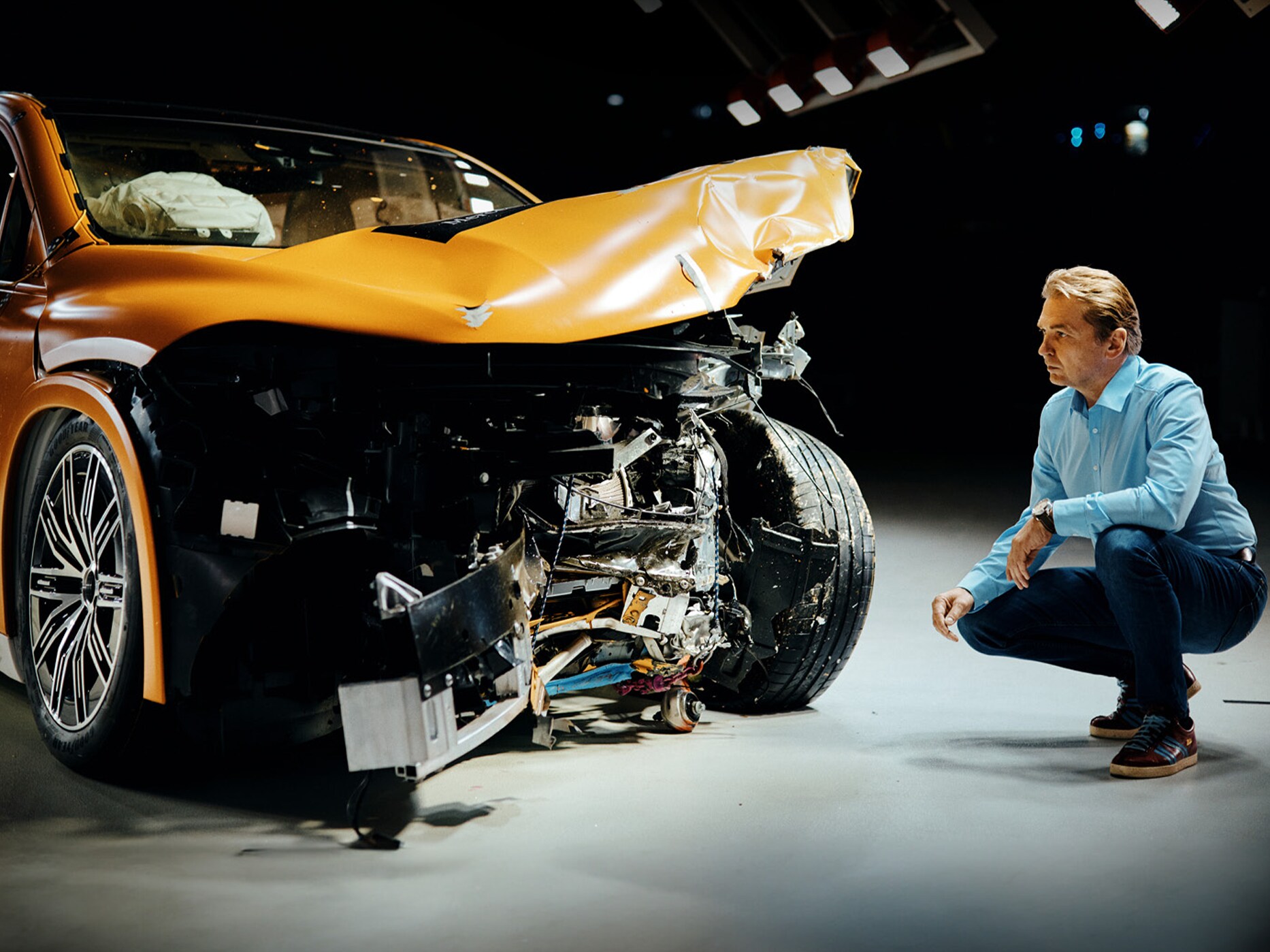 En krocktestsexpert undersöker en frontalkrockad Mercedes-Benz.
