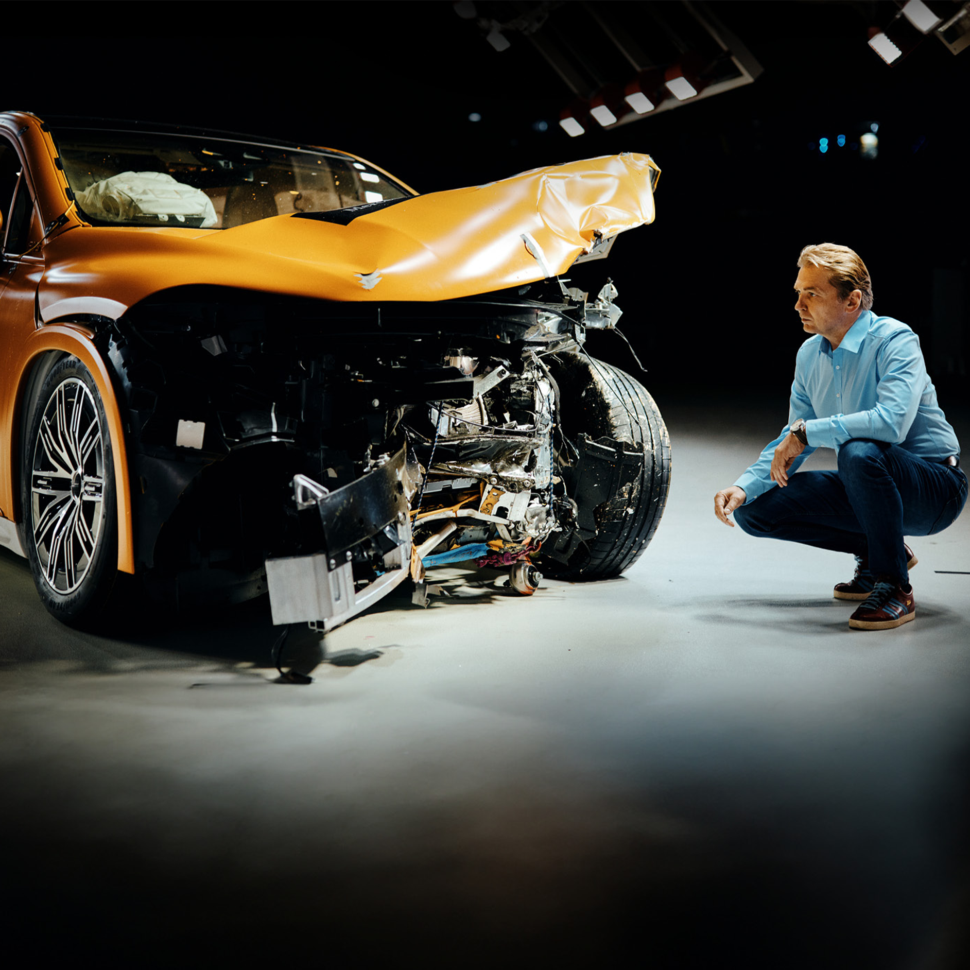 Experter på krocktester | Säkerhet | Mercedes-Benz En krocktestsexpert undersöker en frontalkrockad Mercedes-Benz.