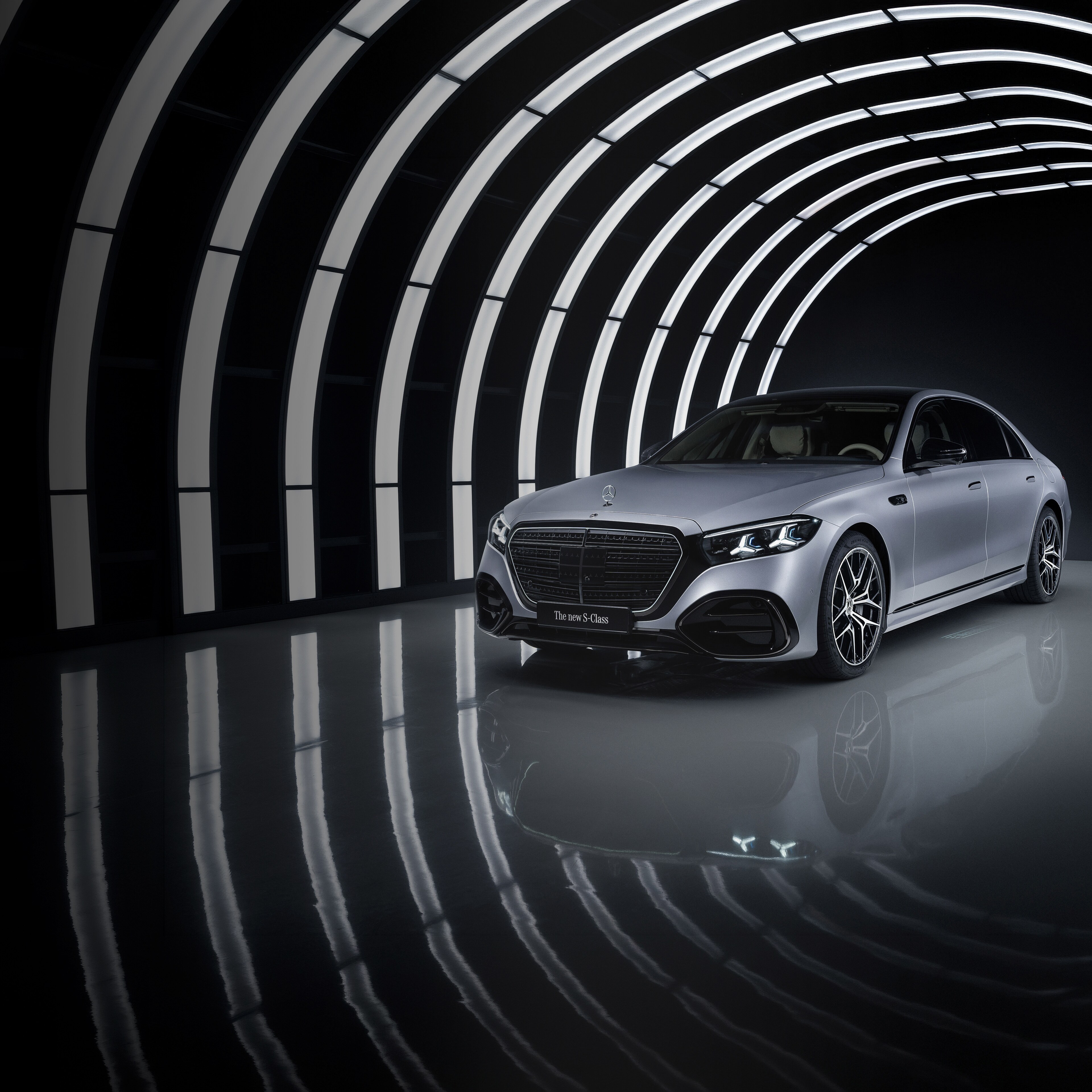 En silvrig Mercedes-Benz S-Klass i ett upplyst garage