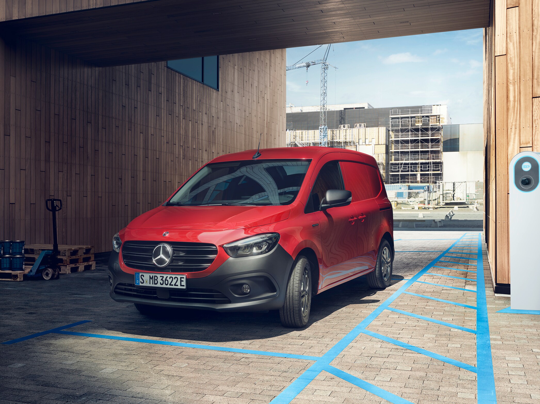 Röd Mercedes-Benz eCitan Skåpbil parkerad bredvid laddstolpe