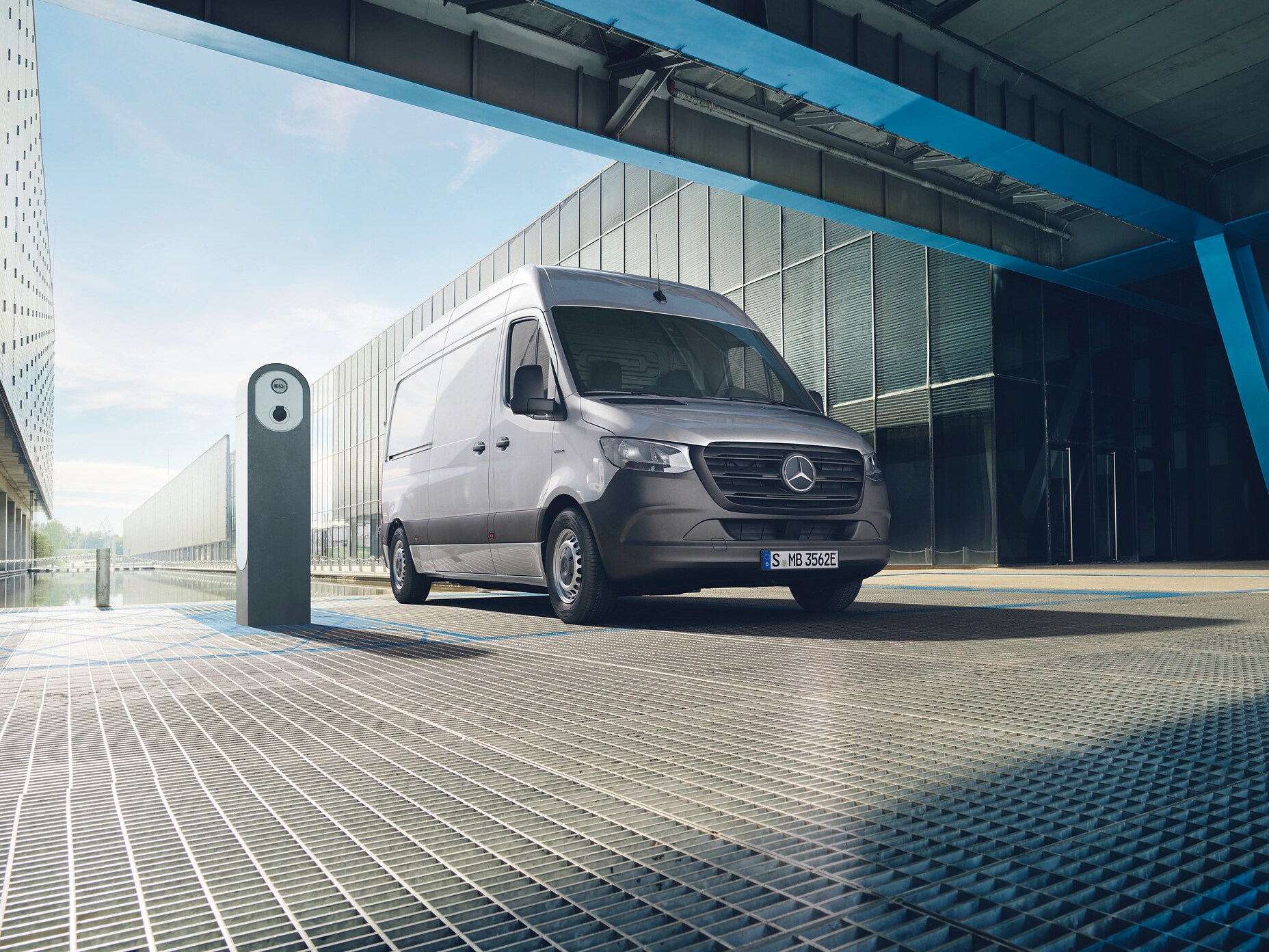 En silvrig Mercedes-Benz eSprinter parkerad vid laddstolpe