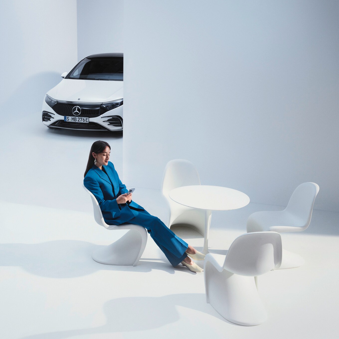 Kvinna som sitter i en futuristisk miljö med en Mercedes-Benz i bakgrunden