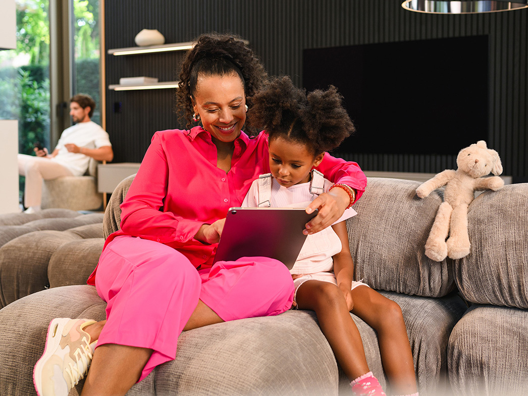 Din digitala översikt | Finansiering | Mercedes-Benz Transportbilar Kvinna och barn sitter i en soffa och använder en surfplatta.