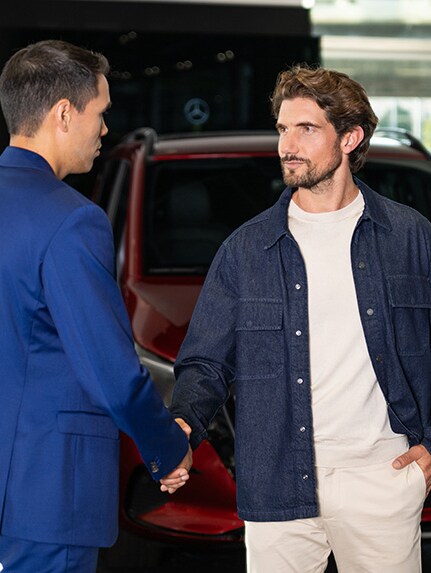 Två män lutar sig mot en Mercedes-Benz transportbil och har en konversation