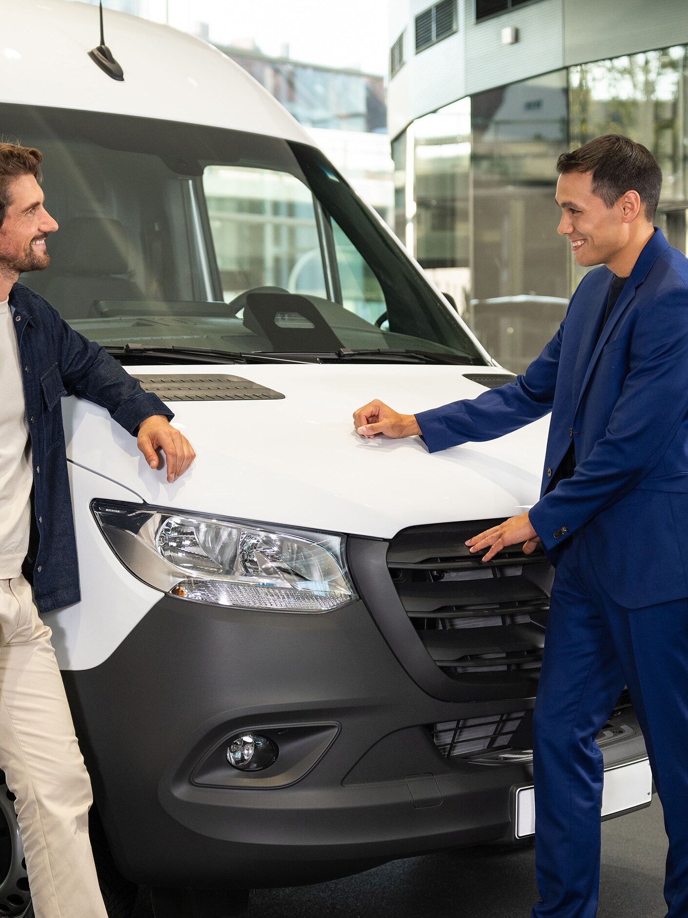 Två män lutar sig mot en Mercedes-Benz transportbil och har en konversation