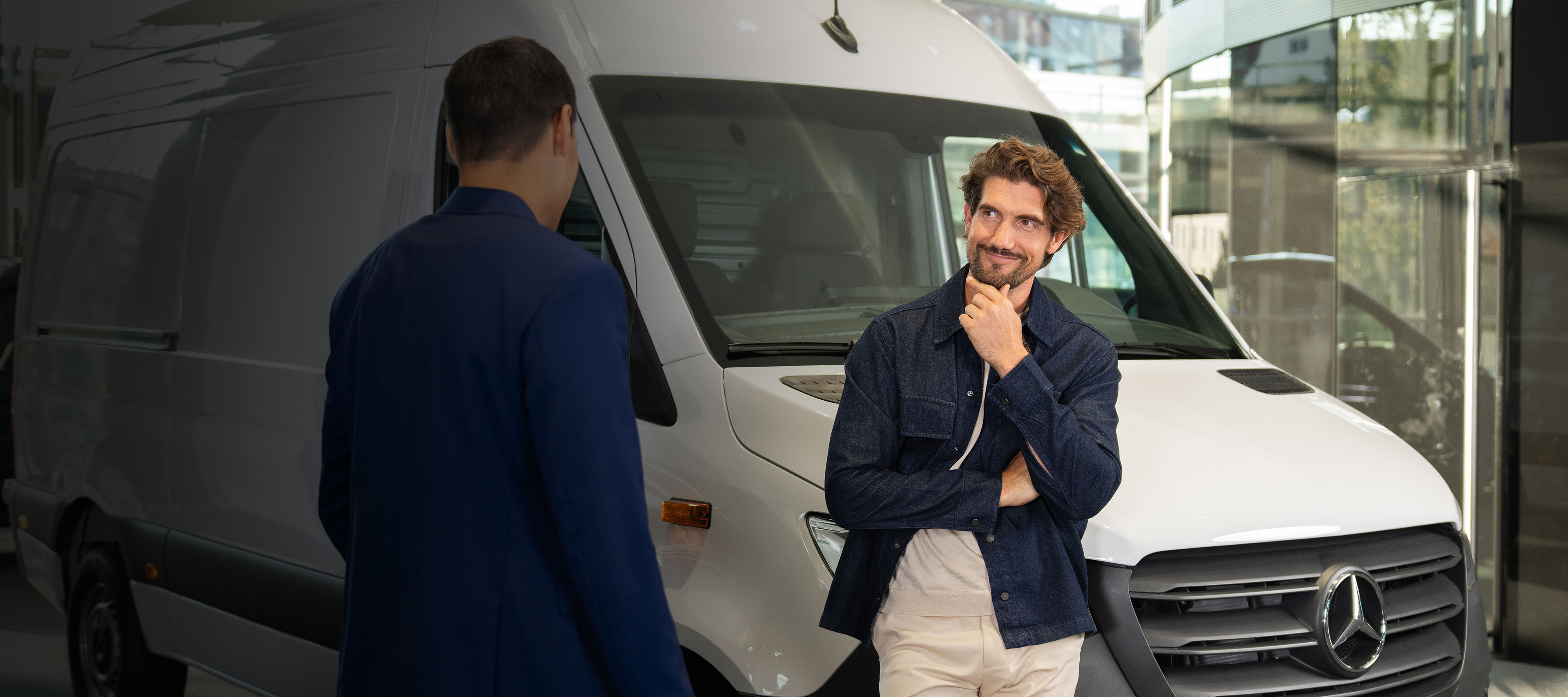 Begagnade transportbilar | Mercedes-Benz Finans | Mercedes-Benz Transportbilar Man lutar sig mot en Mercedes-Benz skåpbil och samtalar med en annan man