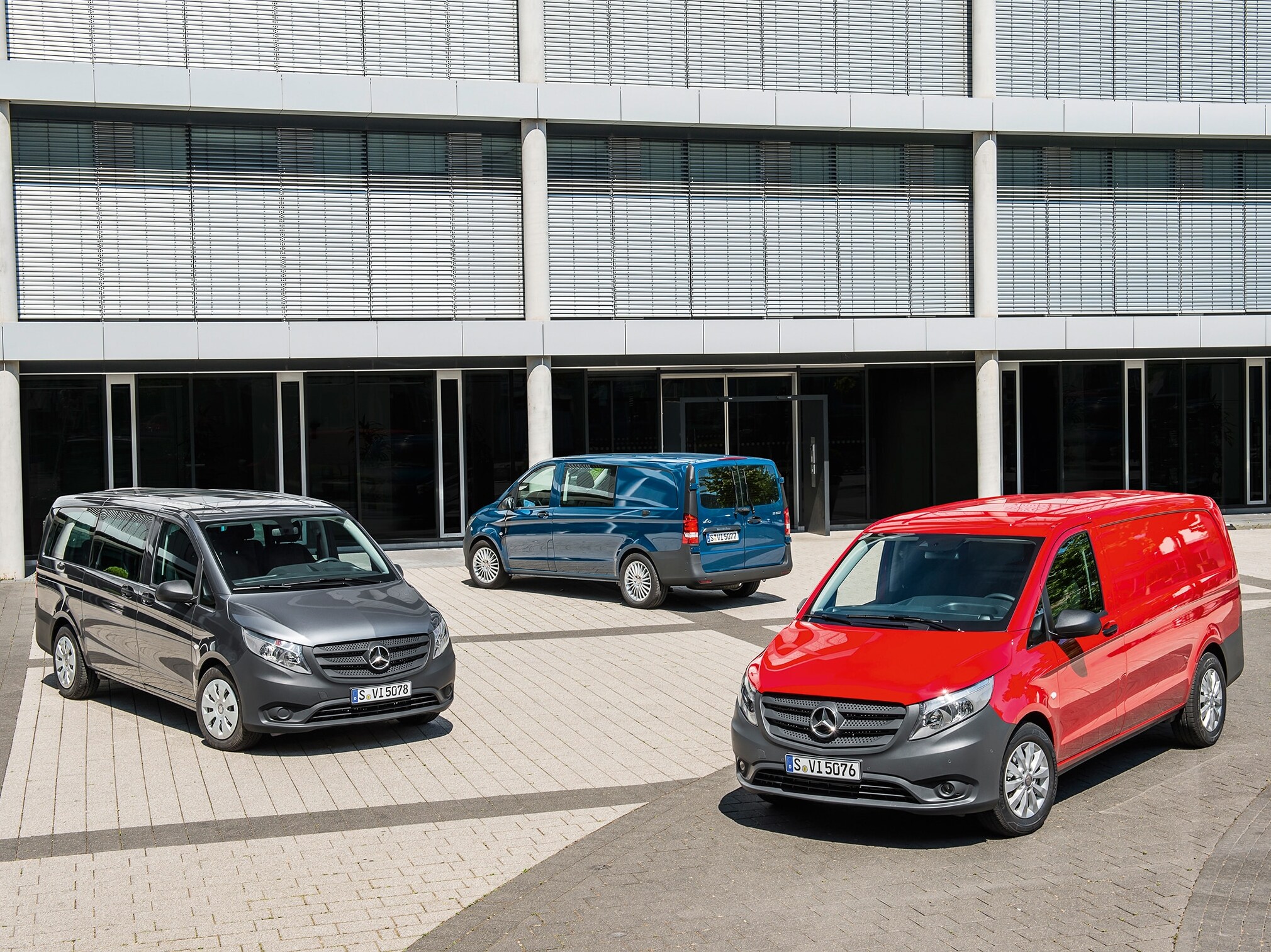 Flera Mercedes‑Benz Vito parkerade framför en modern kontorsbyggnad