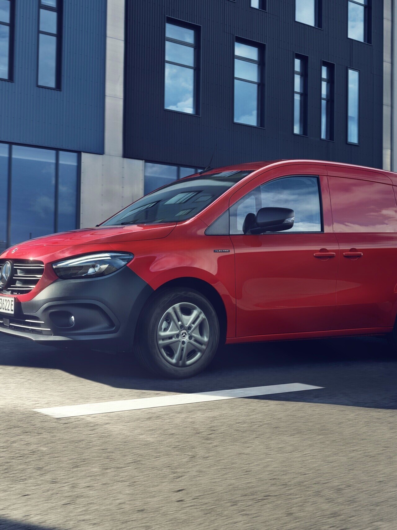 Röd eCitan Skåpbil från Mercedes-Benz framför lägenhetskomplex