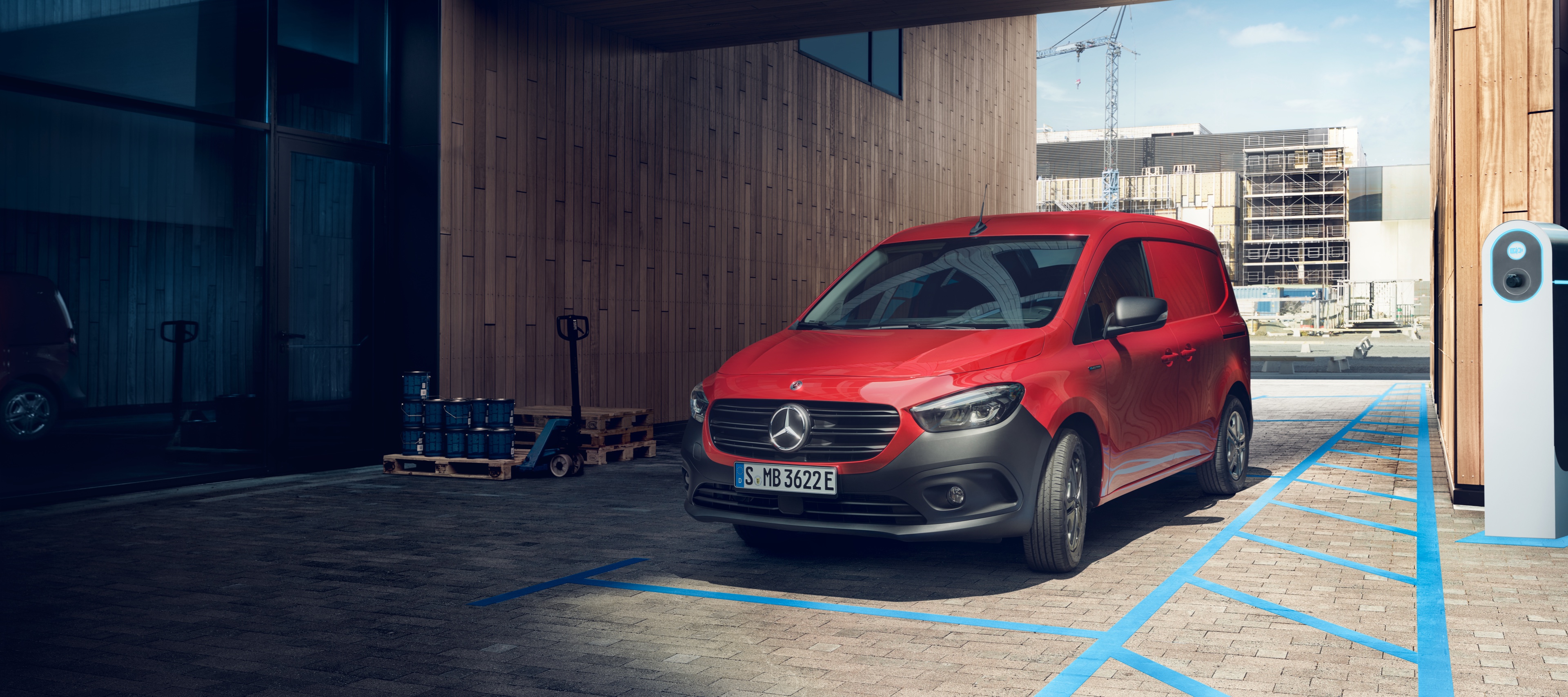 Leasa helelektriska eCitan | Mercedes-Benz Transportbilar Röd elektrisk eCitan parkerad bredvid Mercedes-Benz Wallbox