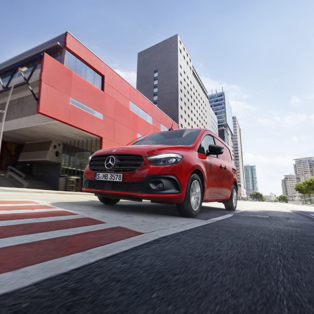 Citan och eCitan | Mercedes-Benz Röd Mercedes-Benz Citan skåpbil kör genom en storstad.