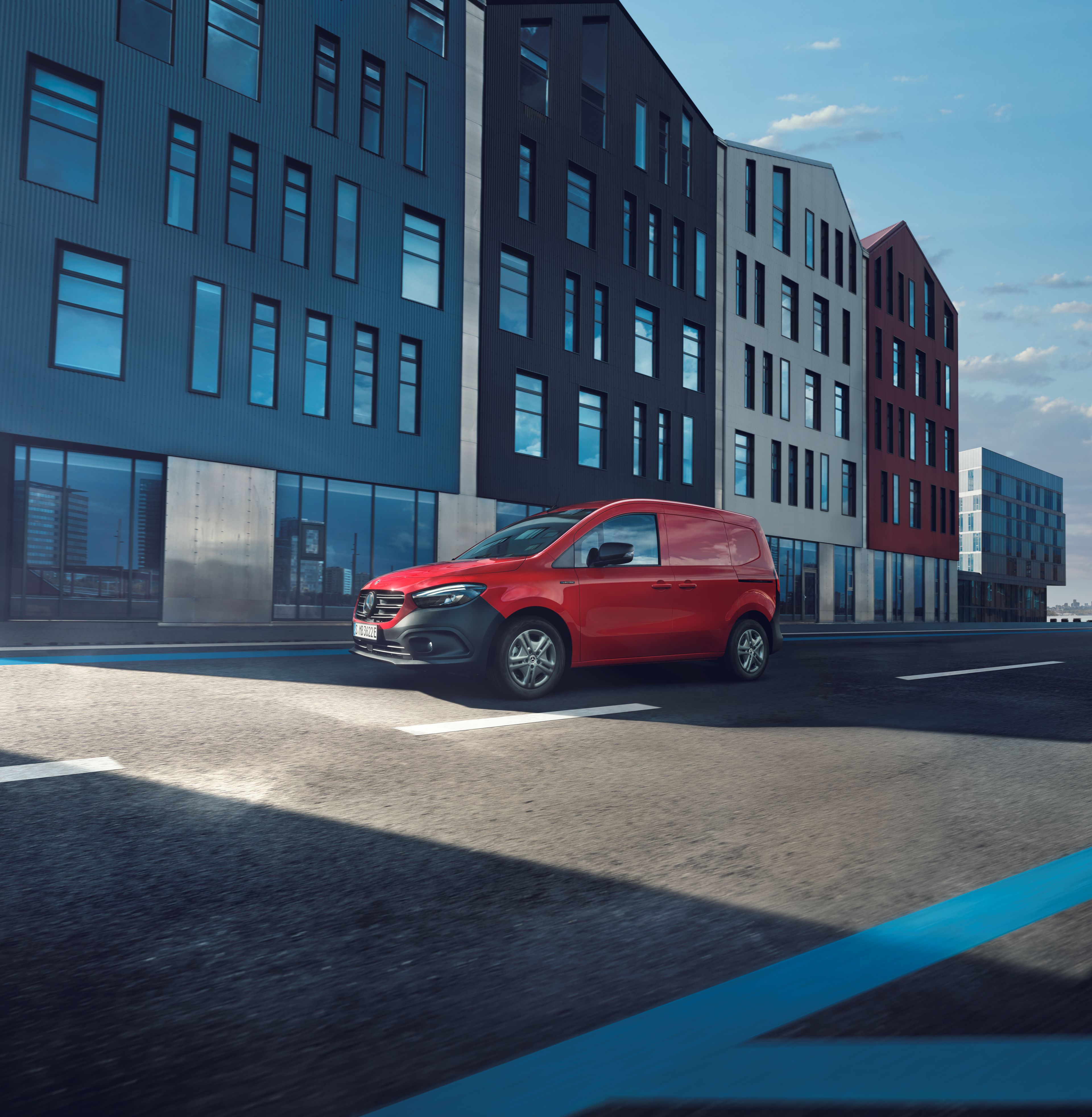 eCitan Skåpbil | Transportbilar | Mercedes-Benz Röd eCitan skåpbil från Mercedes-Benz kör på väg i storstad.