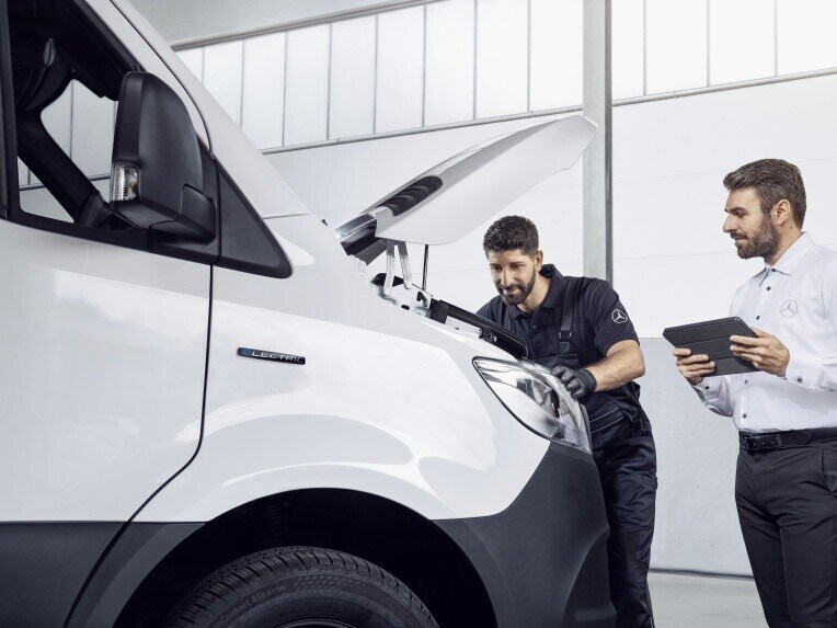 Två Mercedes-Benz servicetekniker utför servicekontroll på transportbil