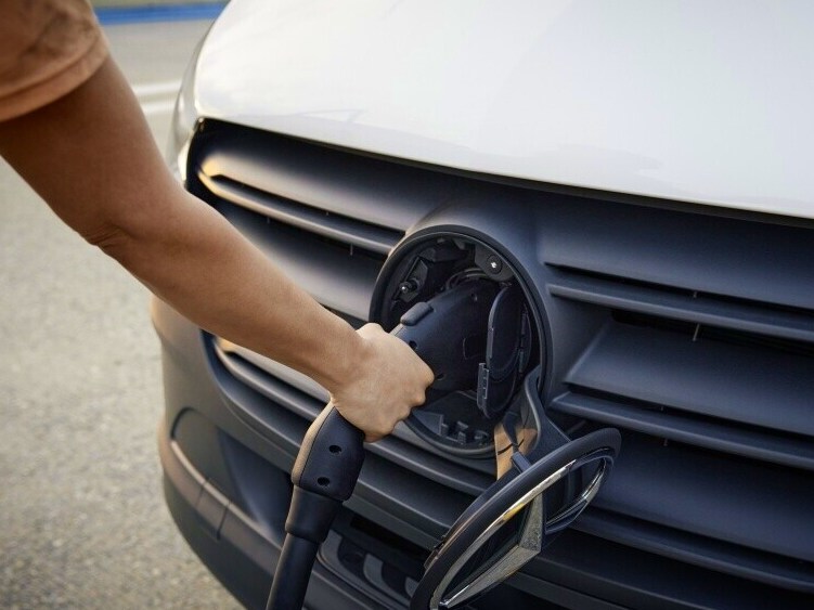 Man ansluter laddkabel till elektrisk Mercedes-Benz transportbil