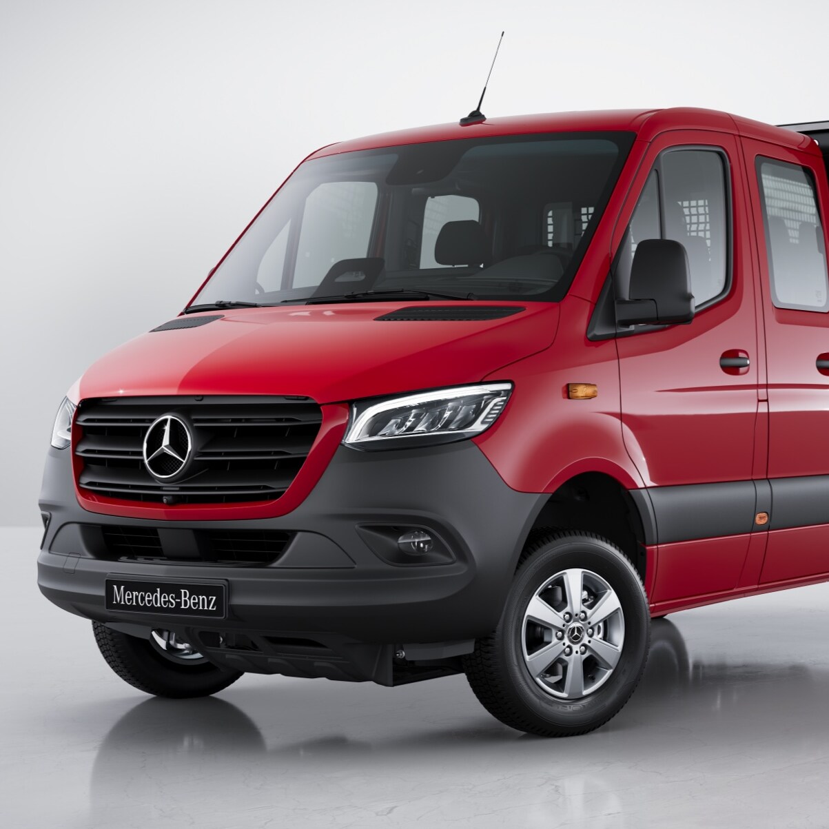 Röd Mercedes Sprinter Flakbil sedd snett framifrån.