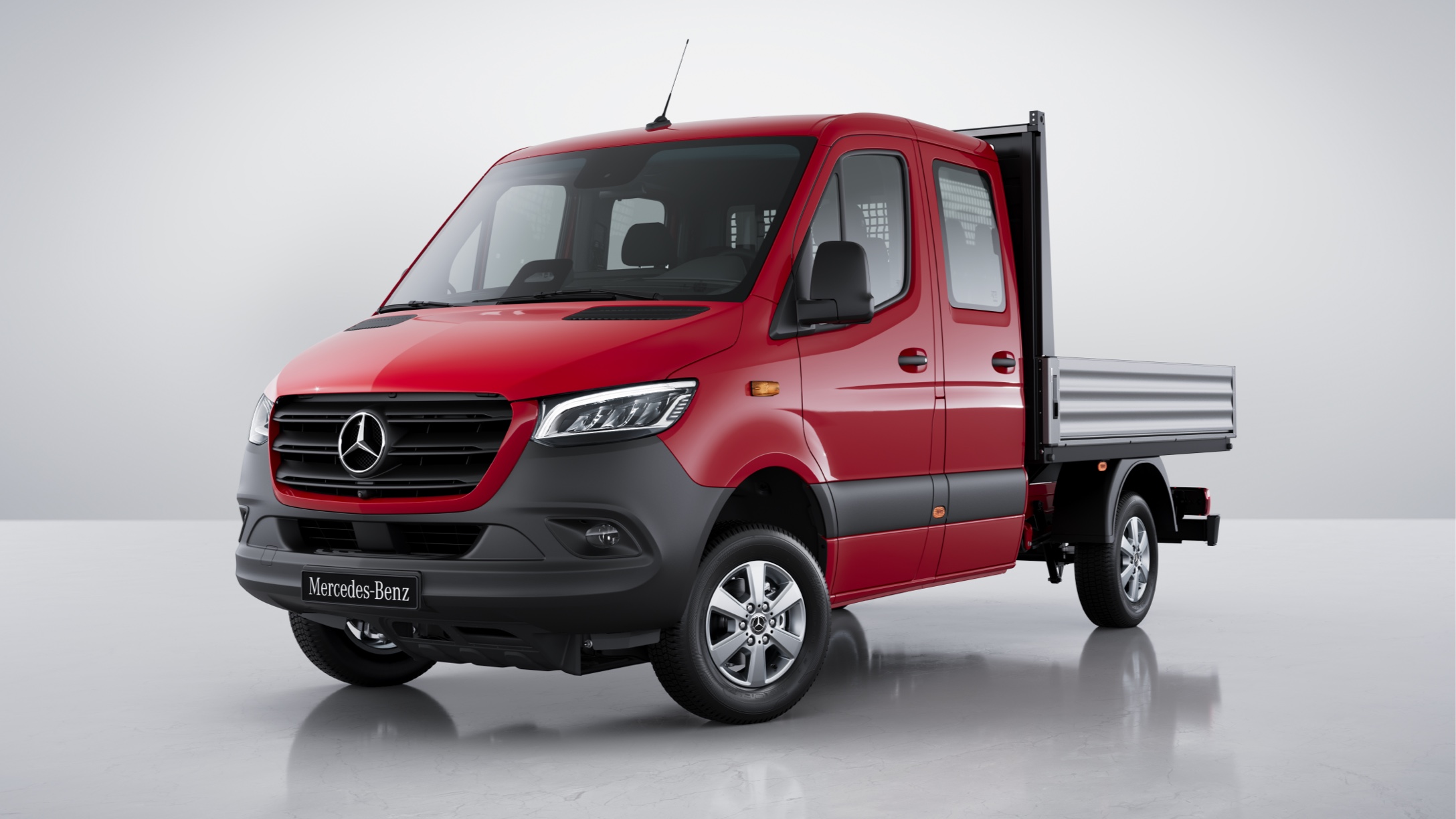 Sprinter Flakbil | Transportbilar | Mercedes-Benz Röd Mercedes Sprinter Flakbil sedd snett framifrån.