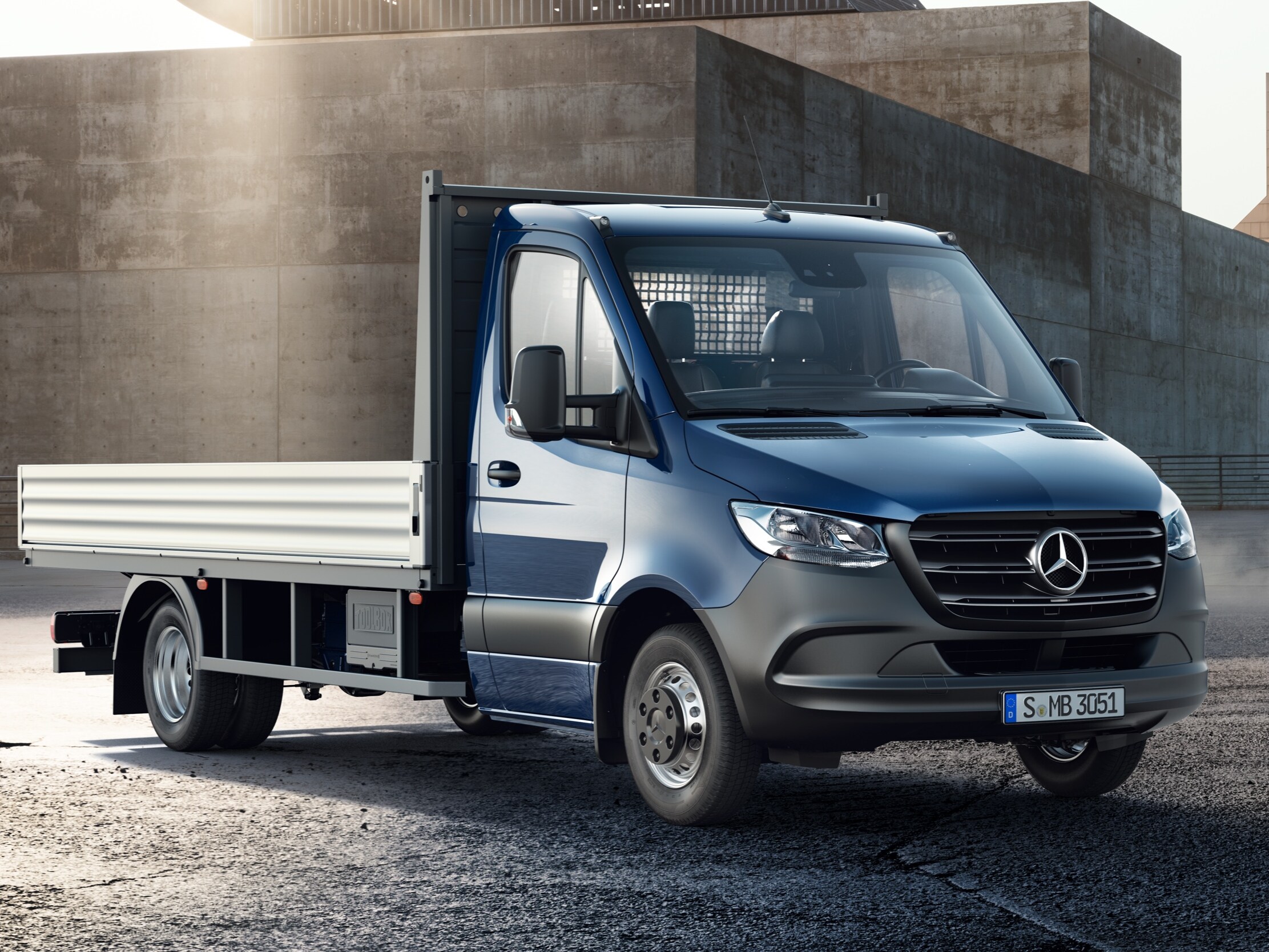 Sprinter flakbil från Mercedes-Benz med uppfällt flak på byggarbetsplats