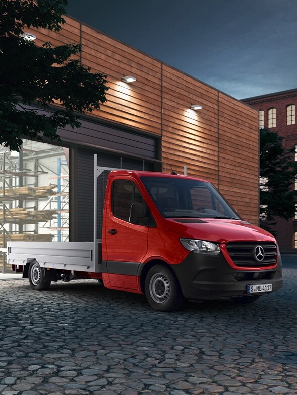 Röd Sprinter Flakbil från Mercedes-Benz framför lagerbyggnad