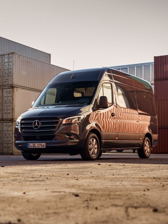 Mörkblå Sprinter Skåpbil från Mercedes-Benz parkerad vid containerhamn