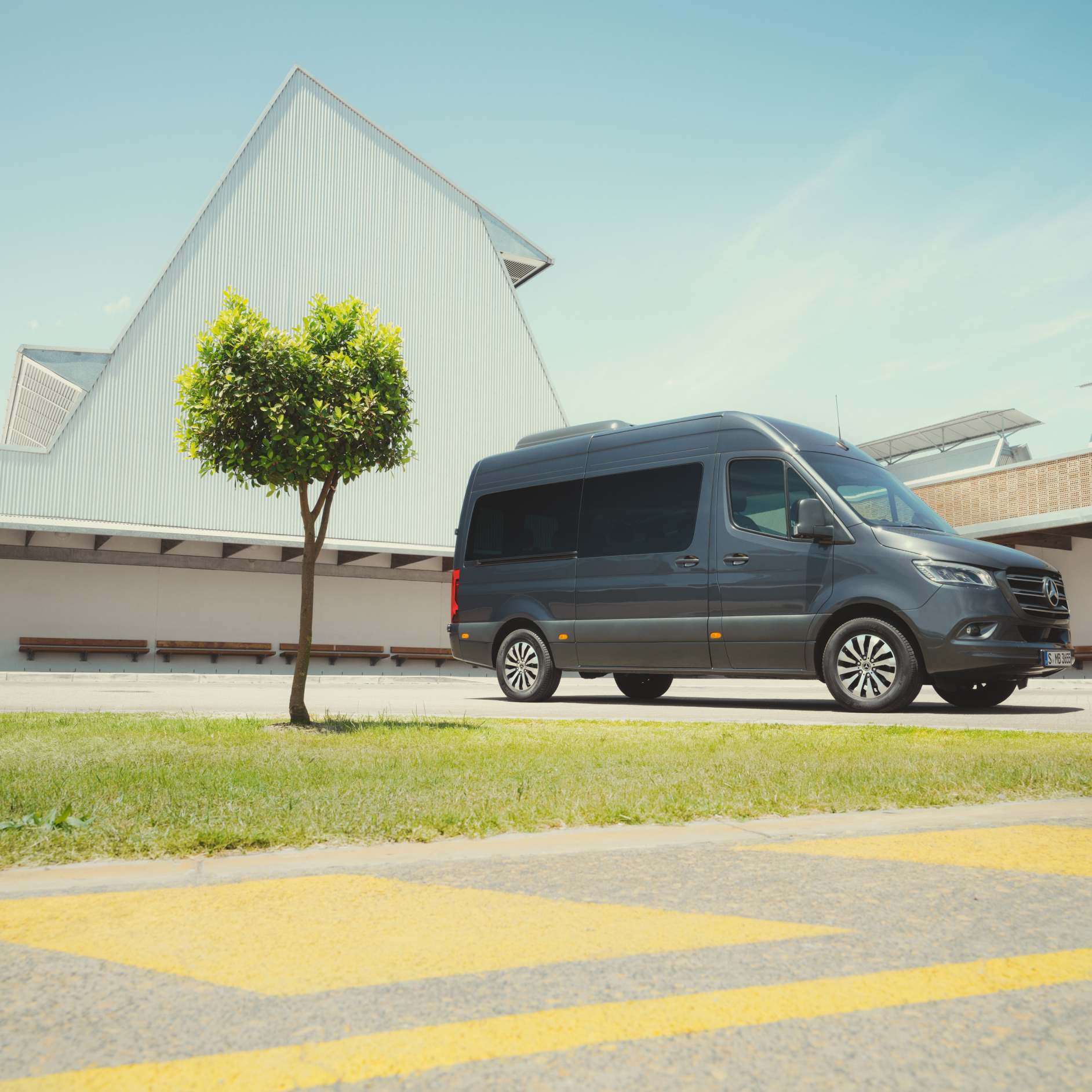 Sprinter | Tourer minibussar och MPV | Mercedes-Benz Transportbilar En Mercedes-Benz Sprinter Tourer står parkerad framför en byggnad