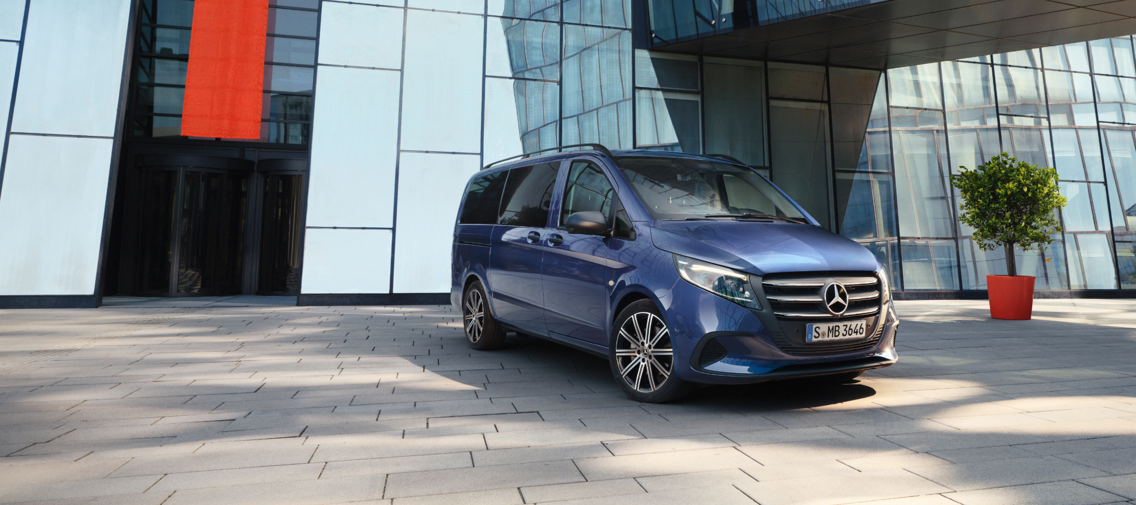 Modellöversikt | Vito Tourer | Mercedes-Benz Transportbilar Mercedes-Benz Vito Tourer framför en kontorsbyggnad